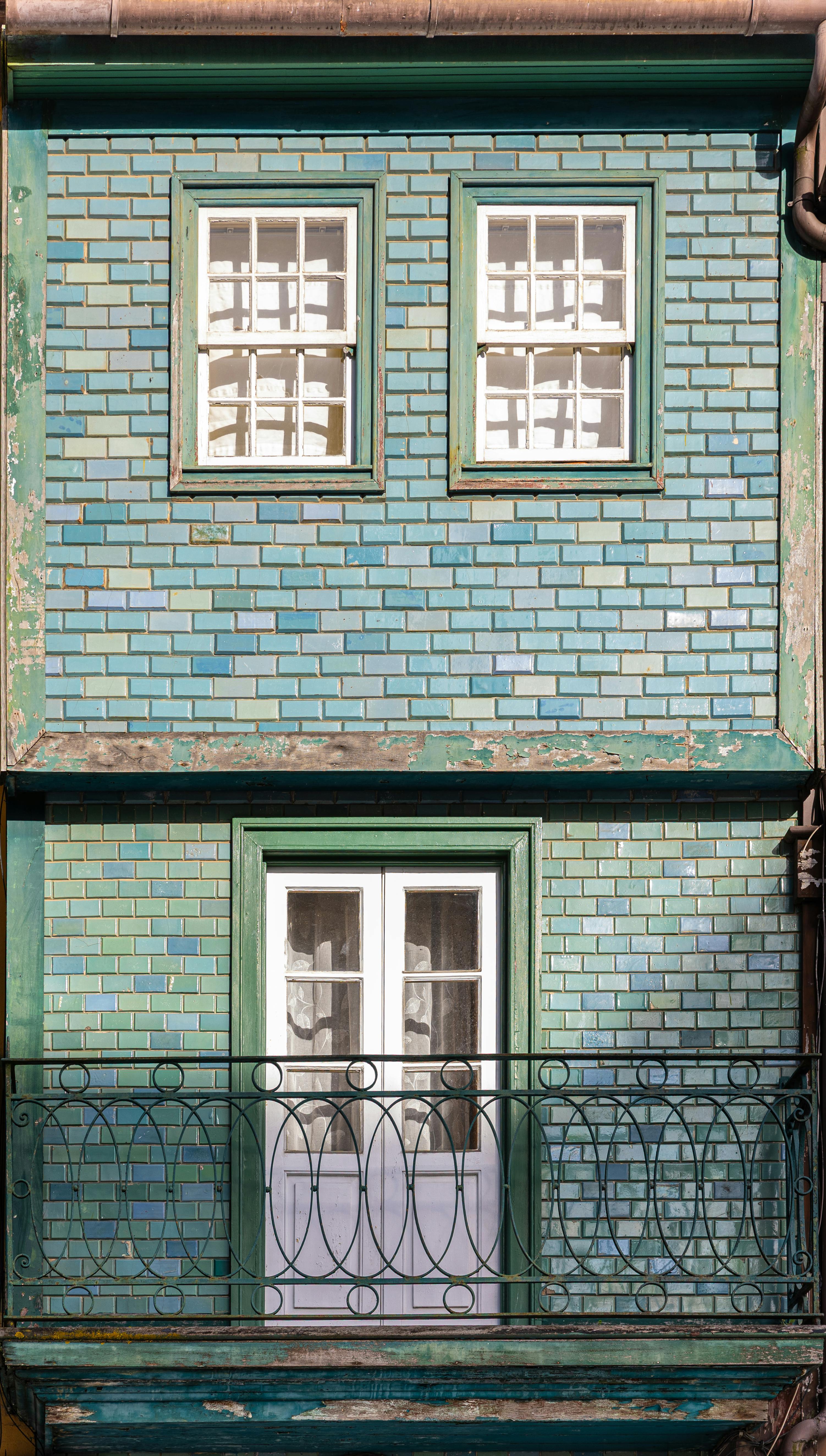 Kostenlos Vintage-farbenfrohe Wohnungsfassade mit Balkon in Porto, Portugal, die den urbanen Architekturstil widerspiegelt. Stock-Foto