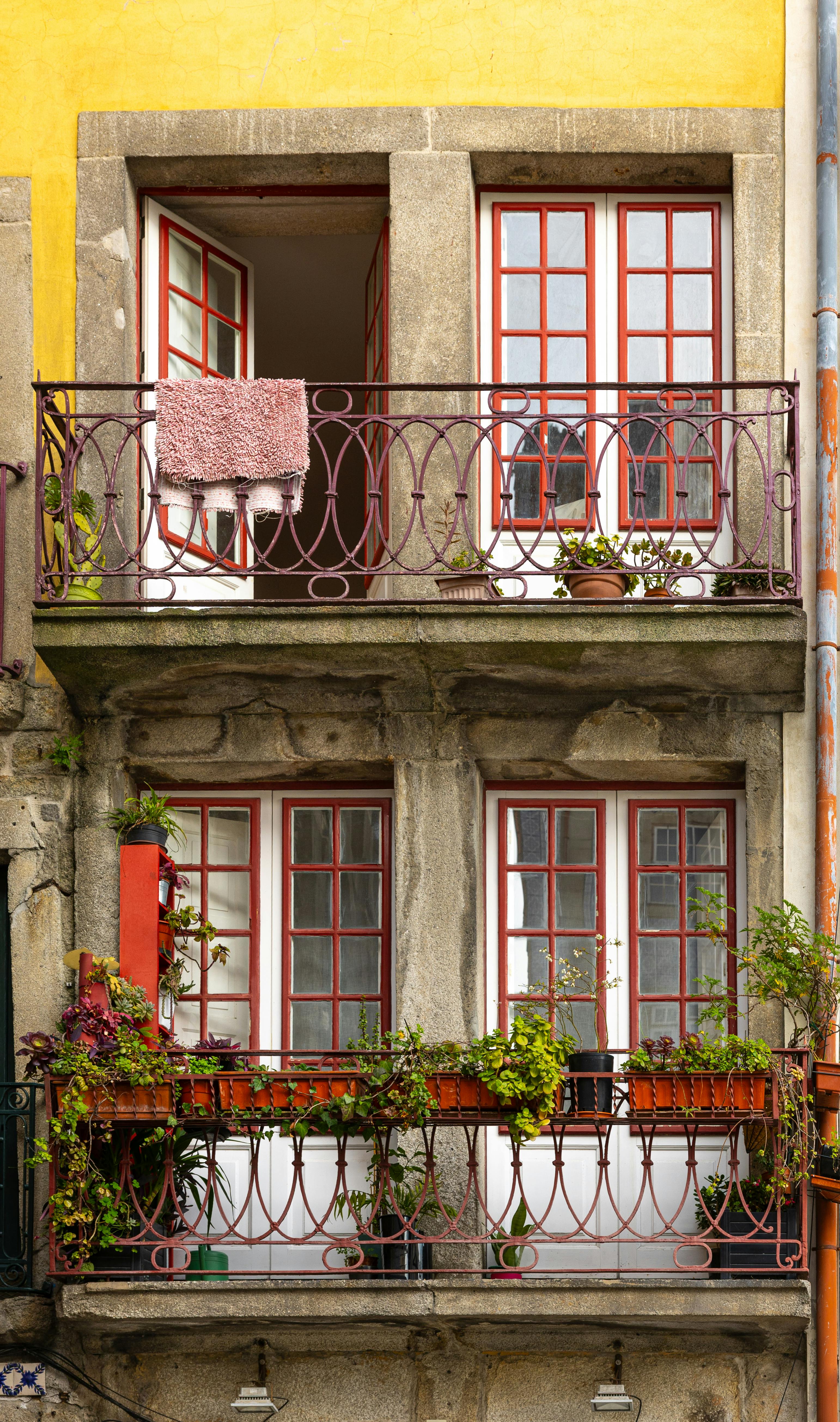 Gratuit Fațada colorată a unui apartament din Porto, cu balcoane vibrante, plante și ferestre deschise. Fotografie de stoc