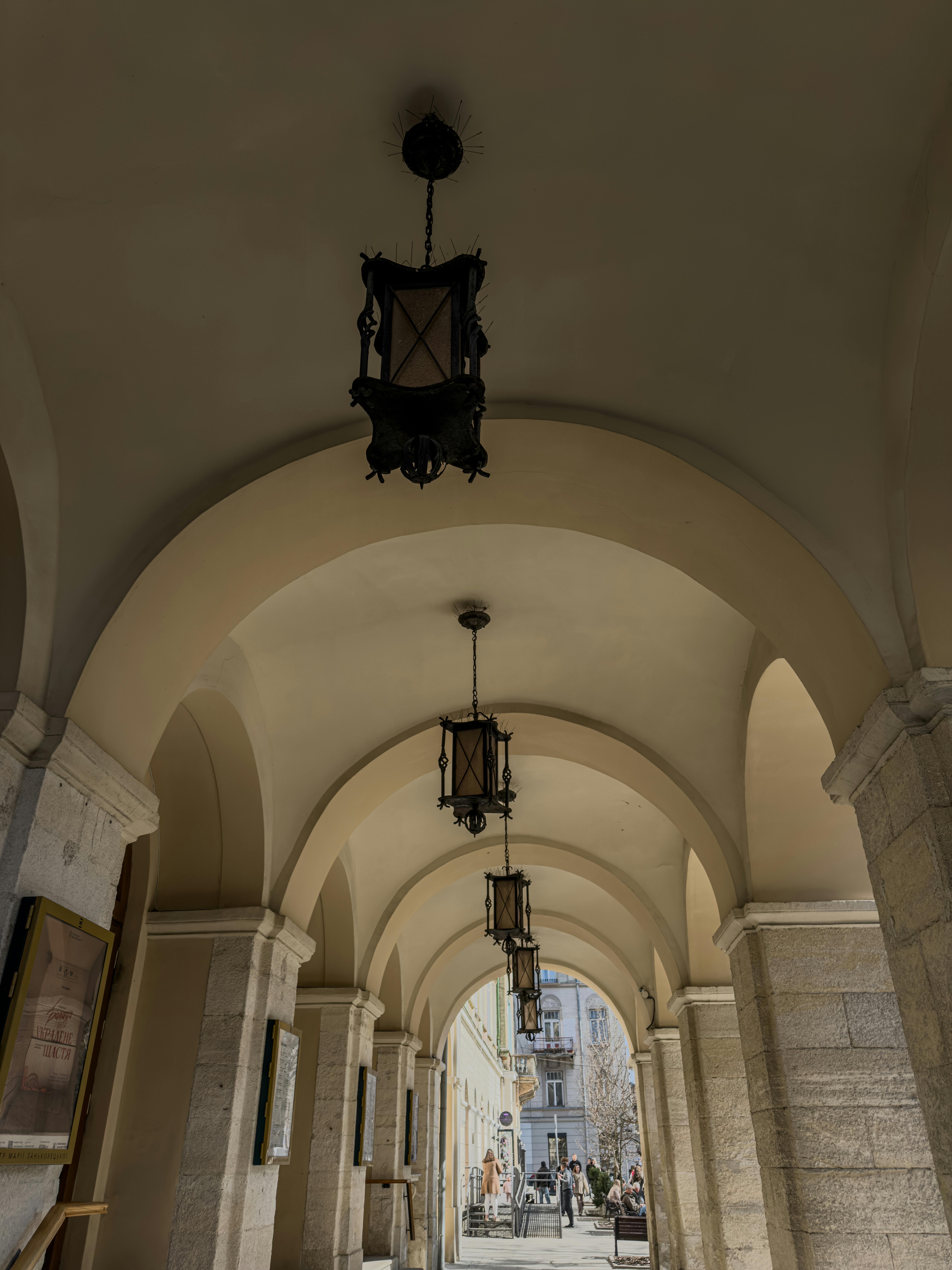ingyenes Íves folyosó Olaszországban vintage lámpásokkal és kőoszlopokkal, klasszikus hangulatot teremtve. Stockfotó