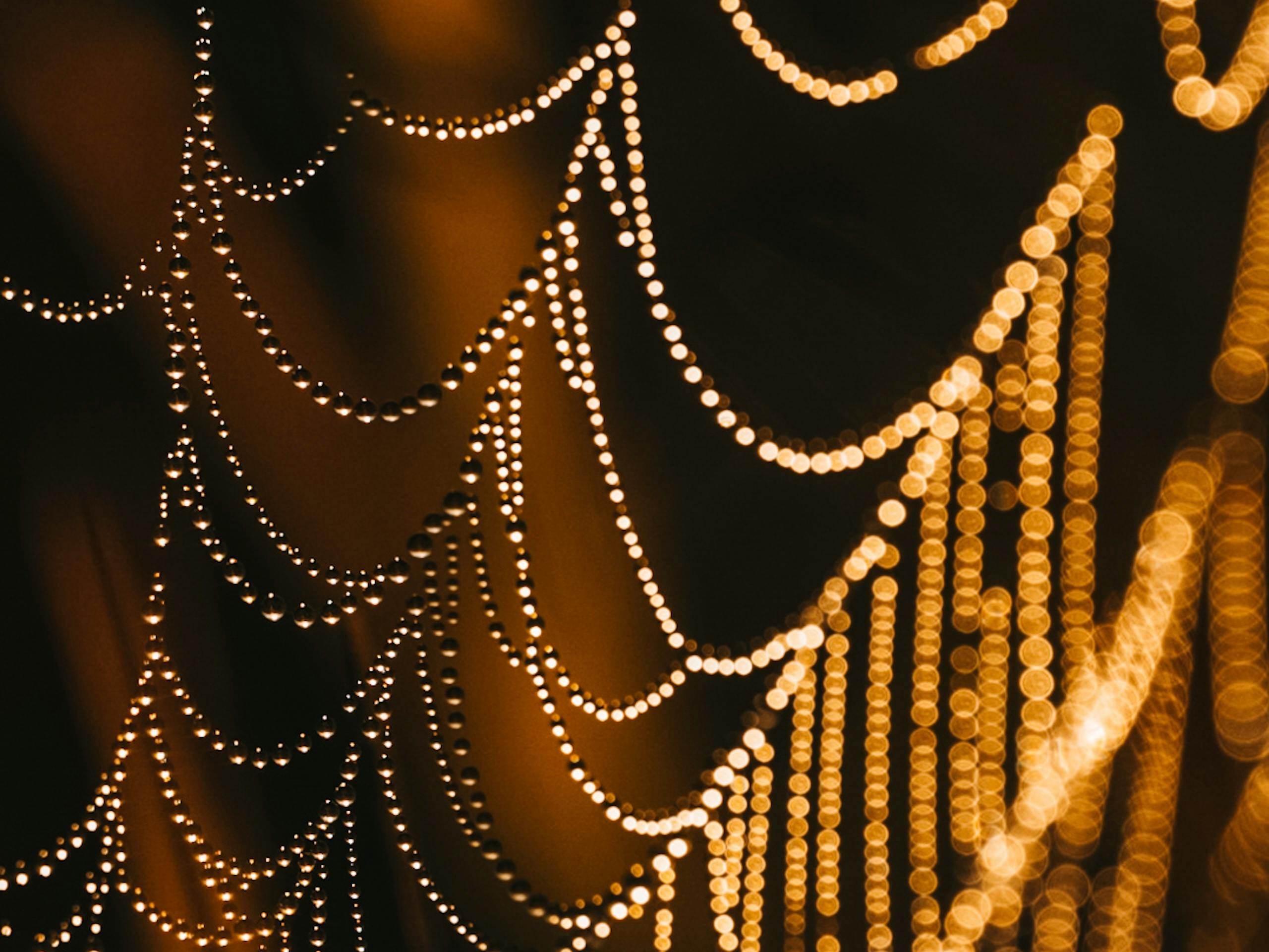 Gratuit Prim-plan abstract cu lumini aurii bokeh care seamănă cu șiruri de caractere. Perfect pentru teme festive și artistice. Fotografie de stoc