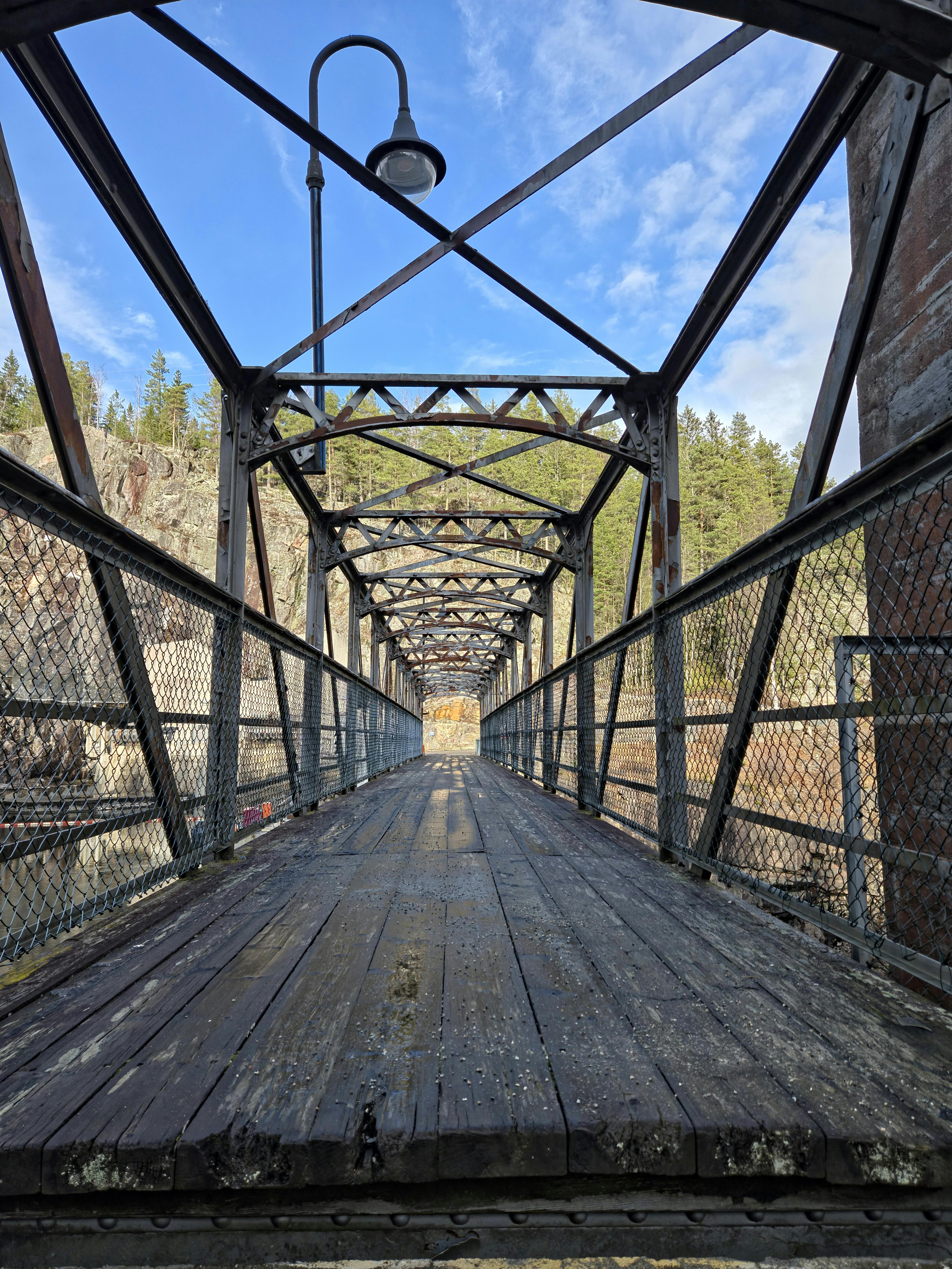Kostenlos Erkunden Sie eine historische Eisenbrücke mit malerischem Blick auf die Natur und blauem Himmel im Hintergrund. Stock-Foto