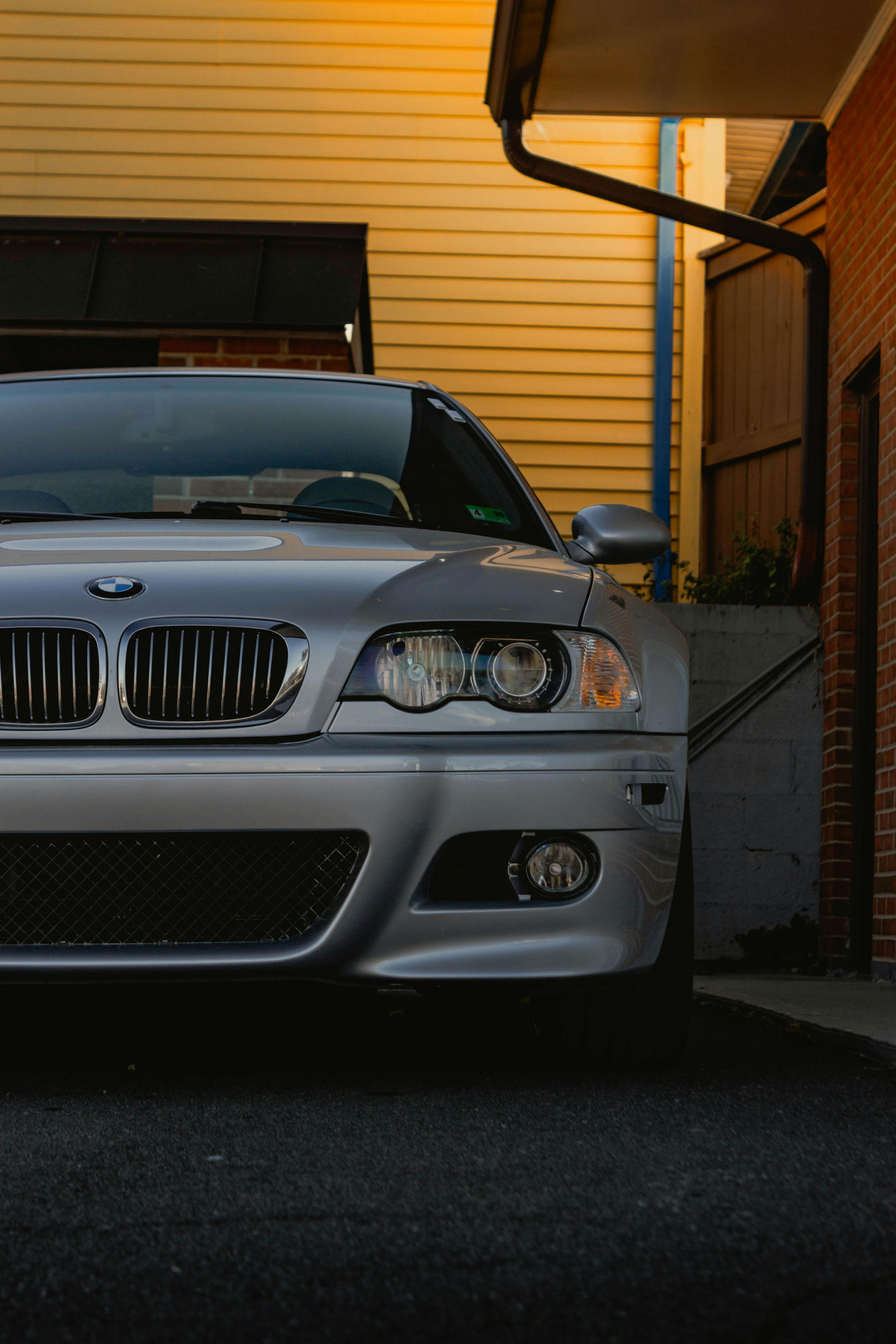 Gratis Detaljeret billede af en elegant sølvfarvet BMW parkeret udendørs mod en moderne baggrund. Lagerfoto