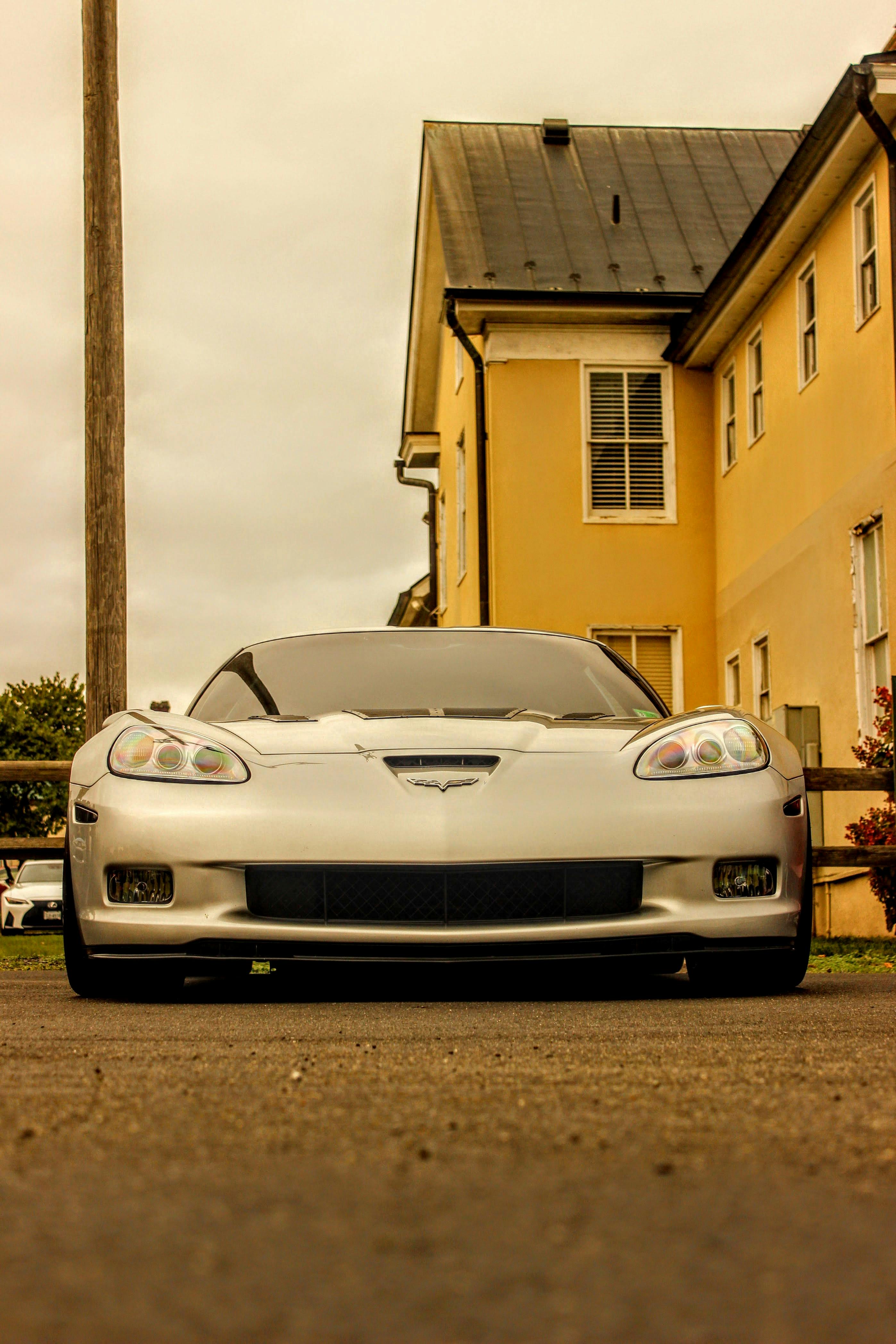 Miễn phí Ảnh chụp từ phía trước một chiếc xe thể thao màu bạc sang trọng đang đậu trong khu dân cư đô thị. Ảnh lưu trữ