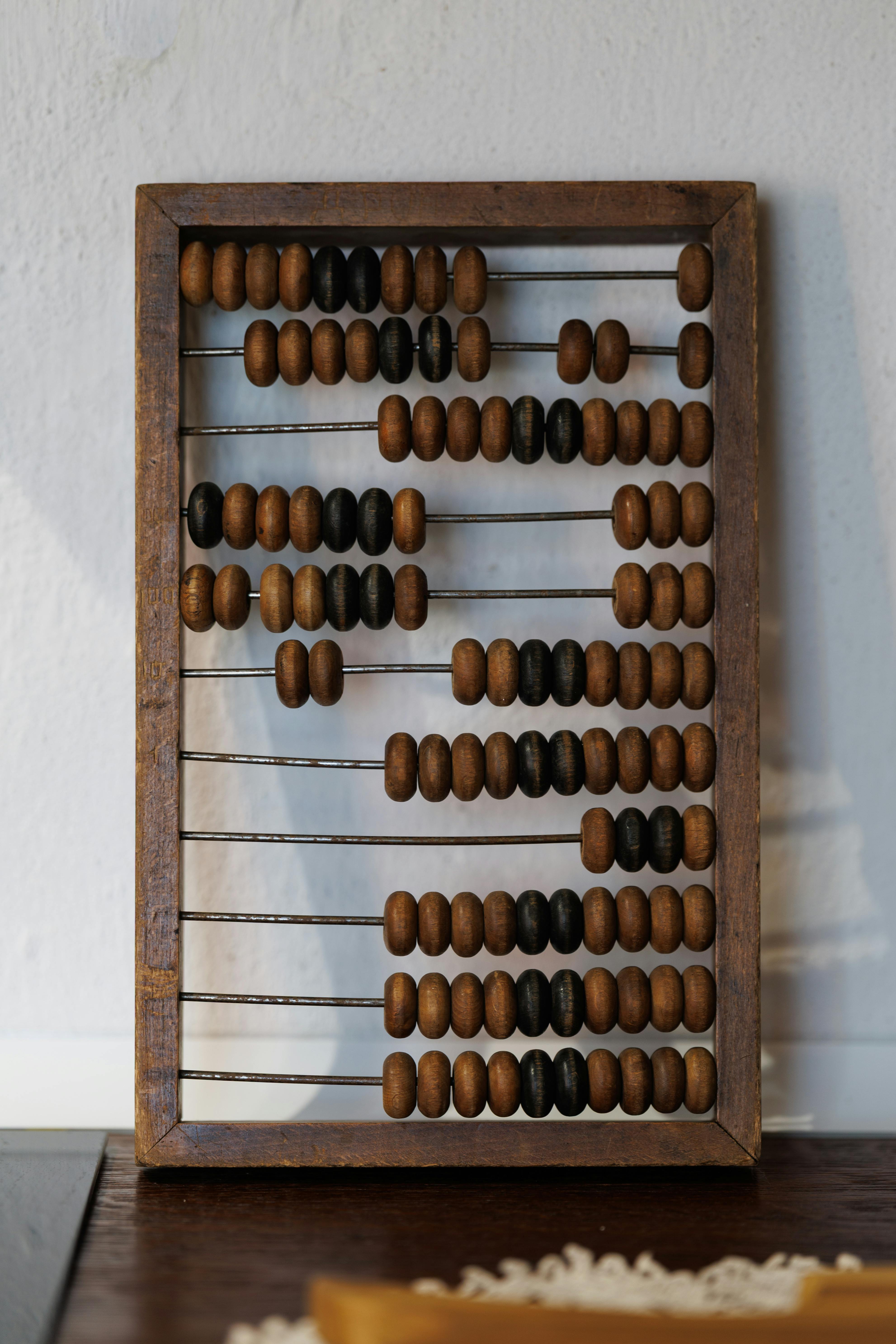 Gratis Vintage træ-abacus med brune og sorte perler på en hvid baggrund. Lagerfoto