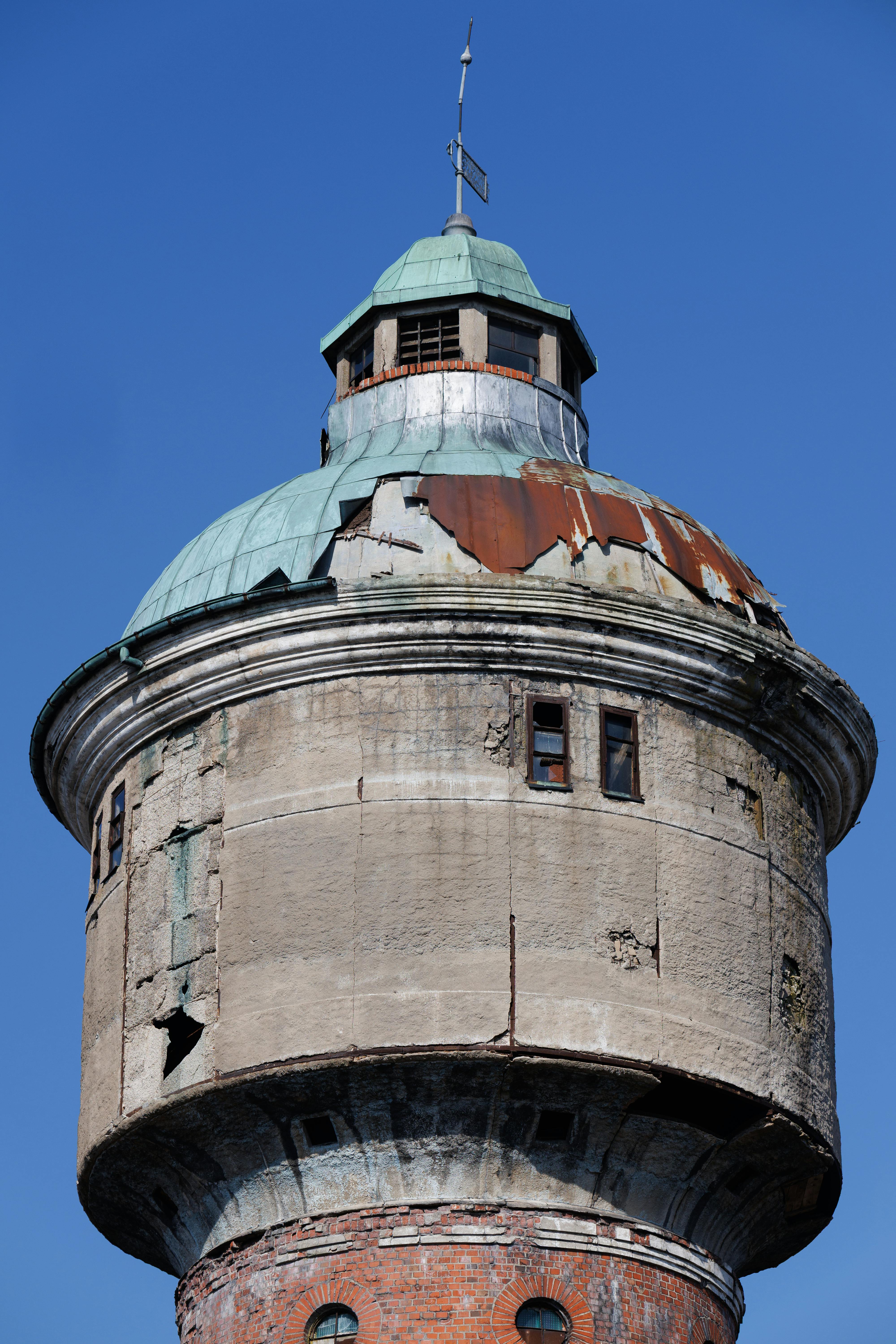 Gratis Una torre dell'acqua d'epoca con la superficie segnata dagli agenti atmosferici, stagliata contro un cielo azzurro limpido a Kaliningrad, in Russia. Foto a disposizione