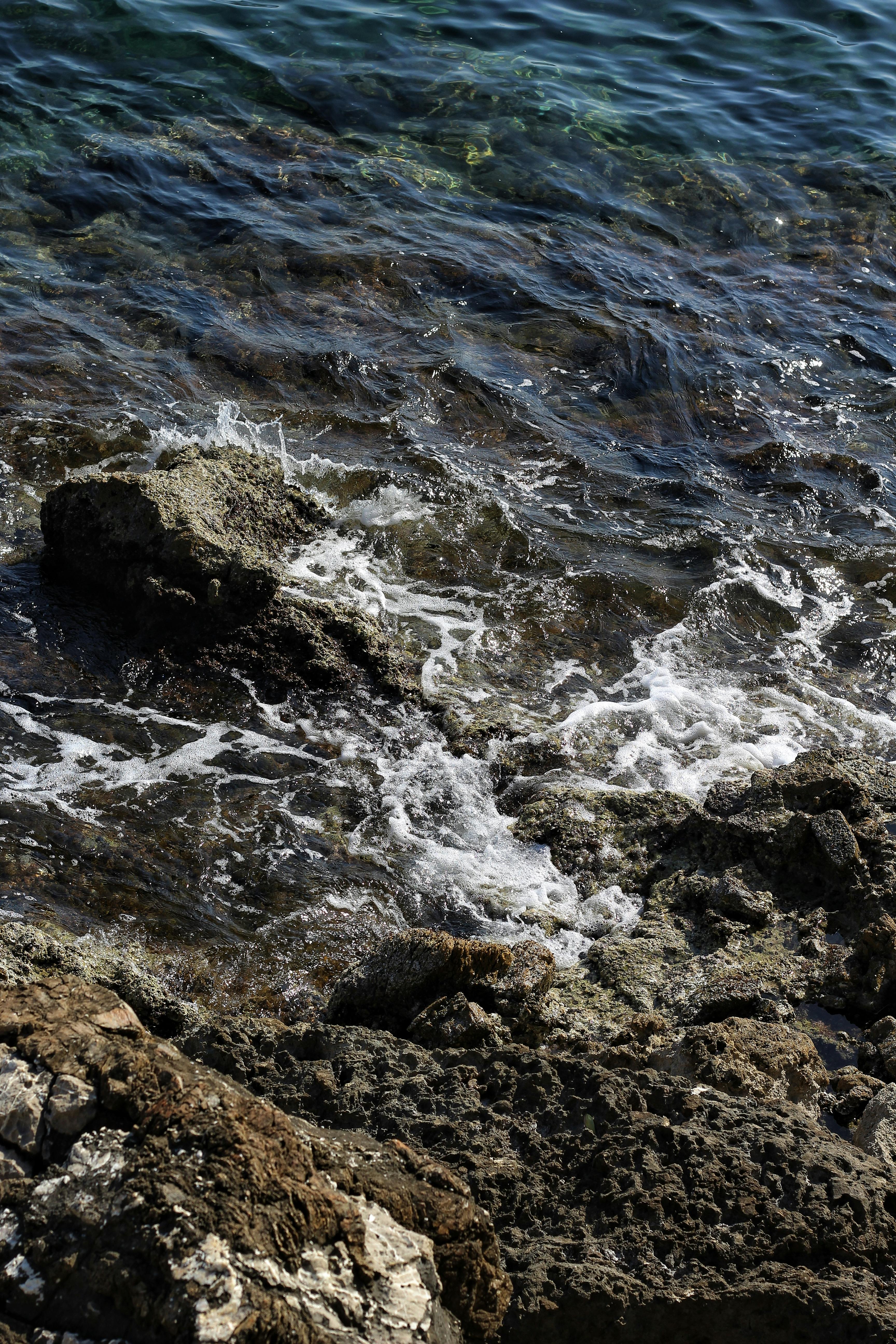 無料 岩だらけの海岸線に打ち寄せる力強い波は、海の自然の美しさと力強さを際立たせている。 写真素材