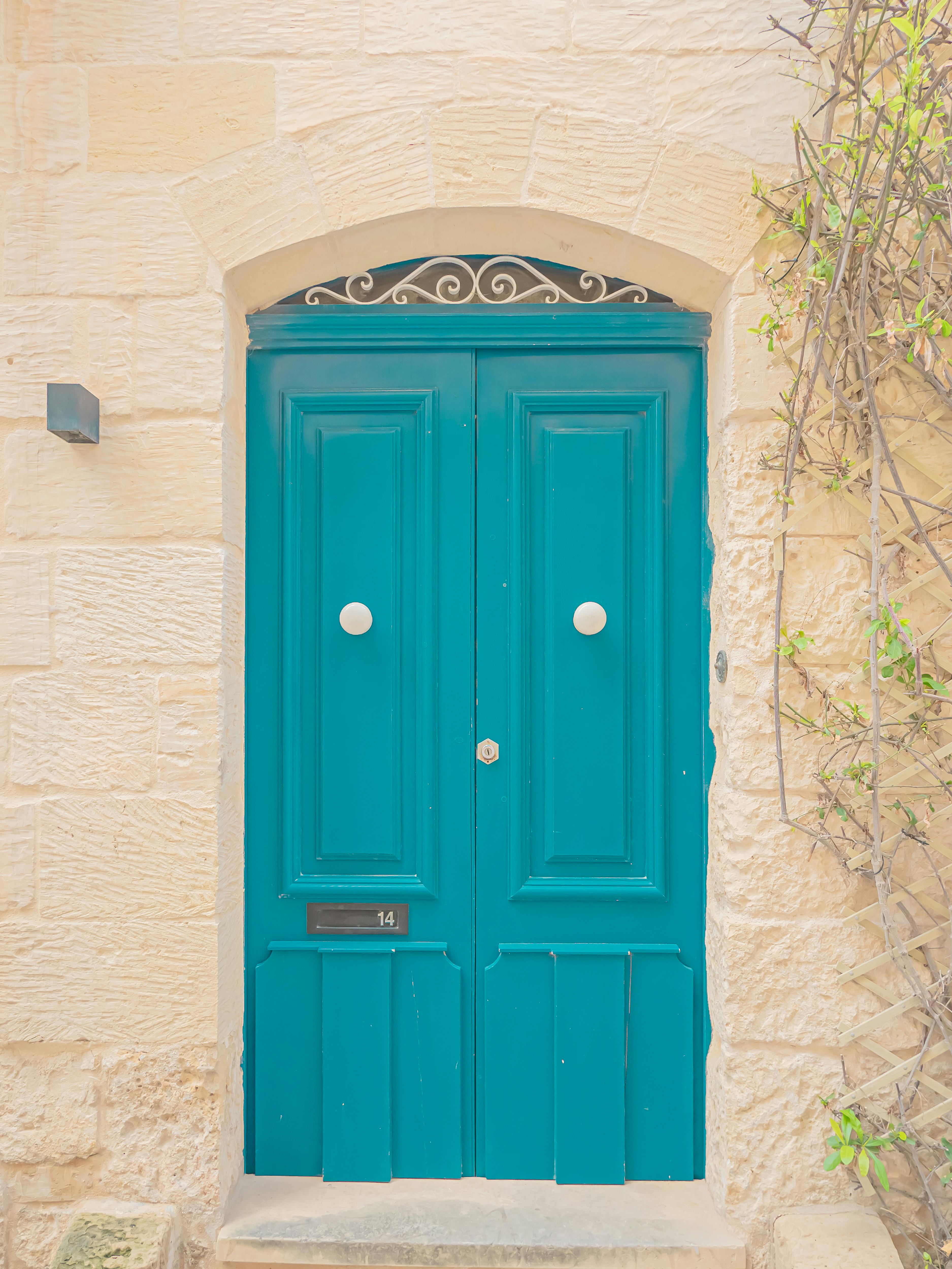 Miễn phí Cánh cửa màu xanh lam rực rỡ được đặt trong bức tường đá cổ kính với những điểm nhấn dây leo tinh tế. Ảnh lưu trữ