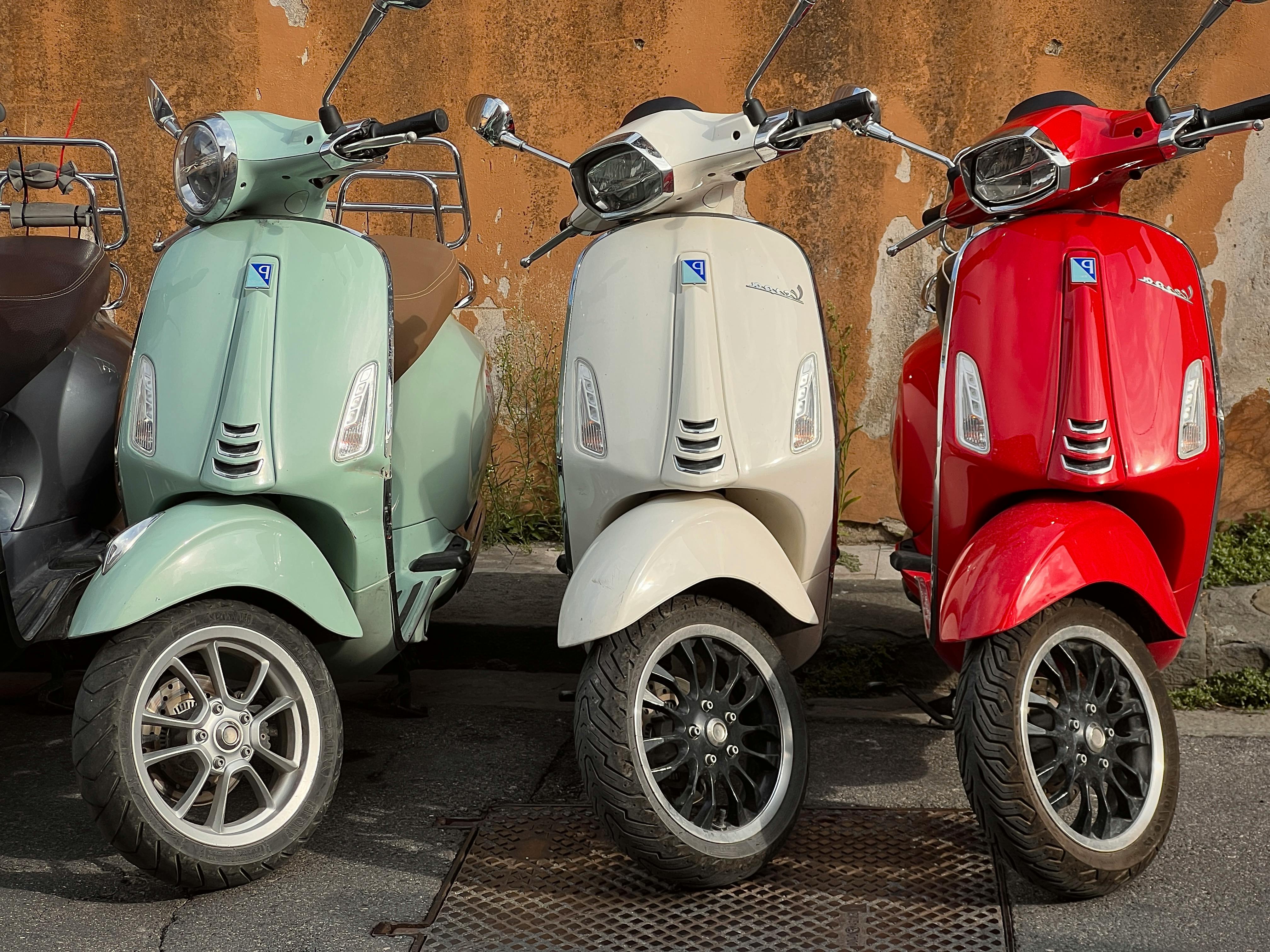 Δωρεάν Τρία vintage σκούτερ σε παστέλ χρώματα παρκαρισμένα δίπλα σε έναν παλιό, φθαρμένο, ανάγλυφο τοίχο. Φωτογραφία από στοκ φωτογραφιών