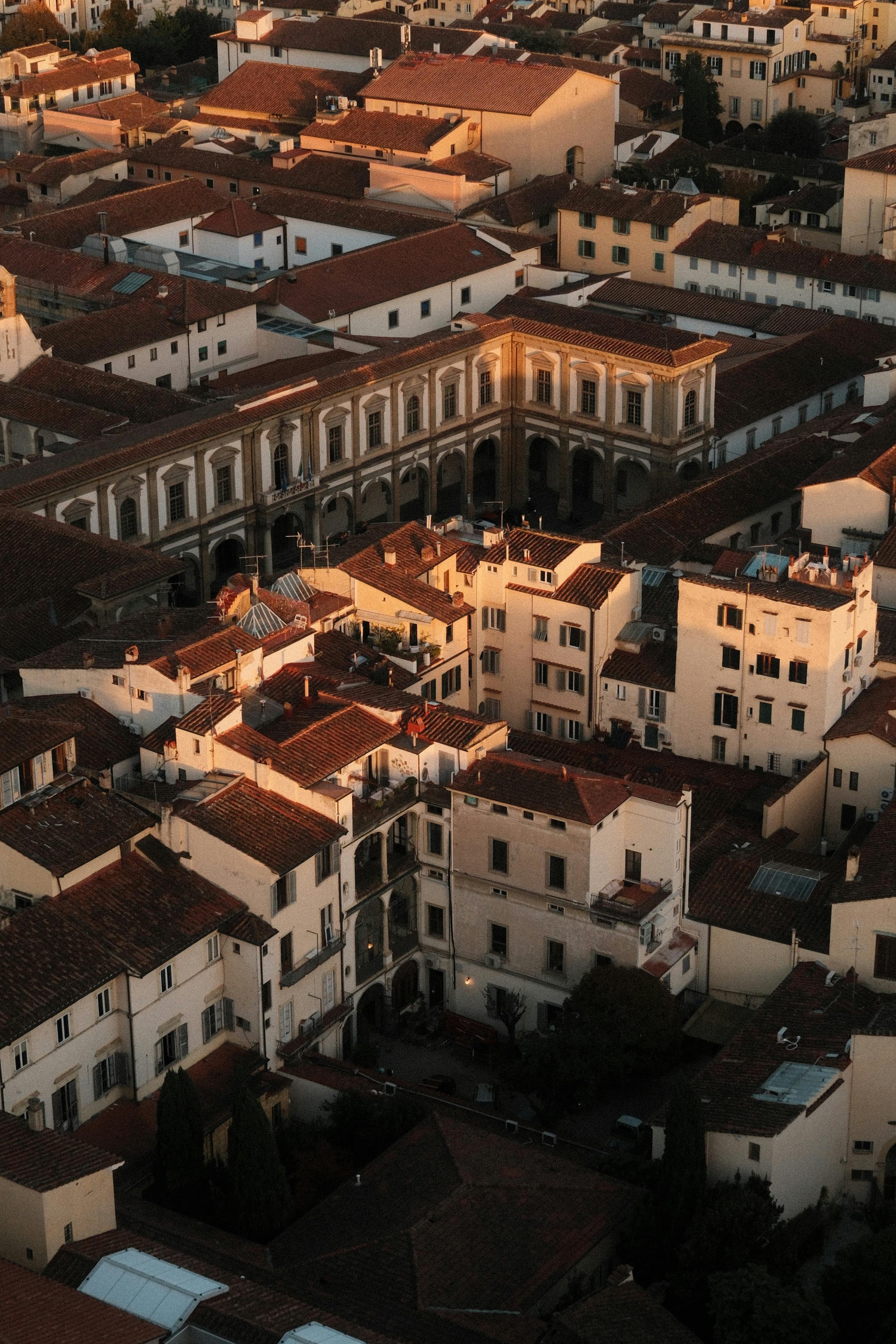 Gratis Fengslende luftfoto av Firenzes historiske arkitektur badet i varmt solnedgangslys. Arkivbilde