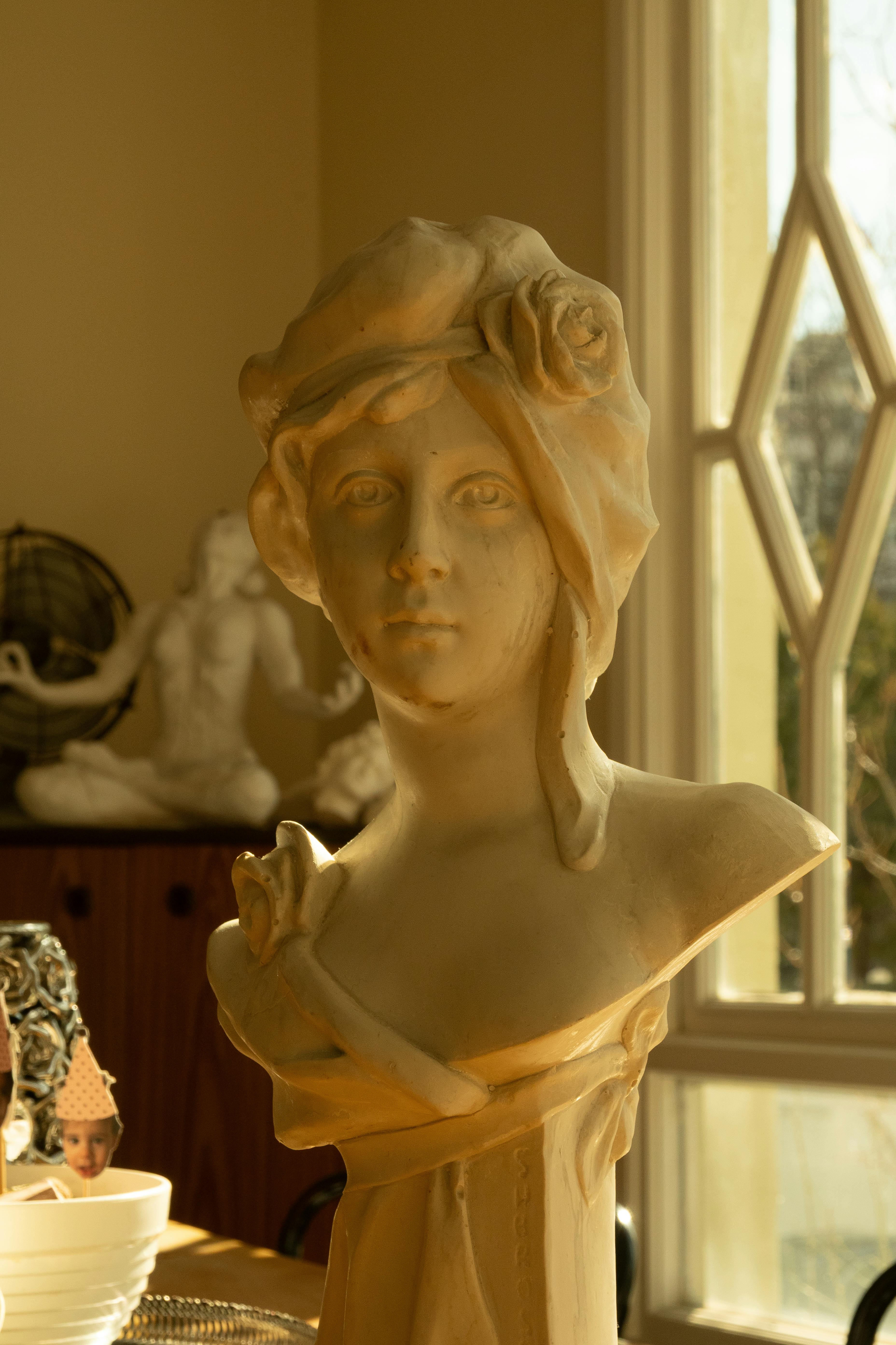 Zadarmo Klasická mramorová busta zaliata teplým slnečným svetlom v interiéri, evokujúca nadčasovú eleganciu. Fotka z fotobanky