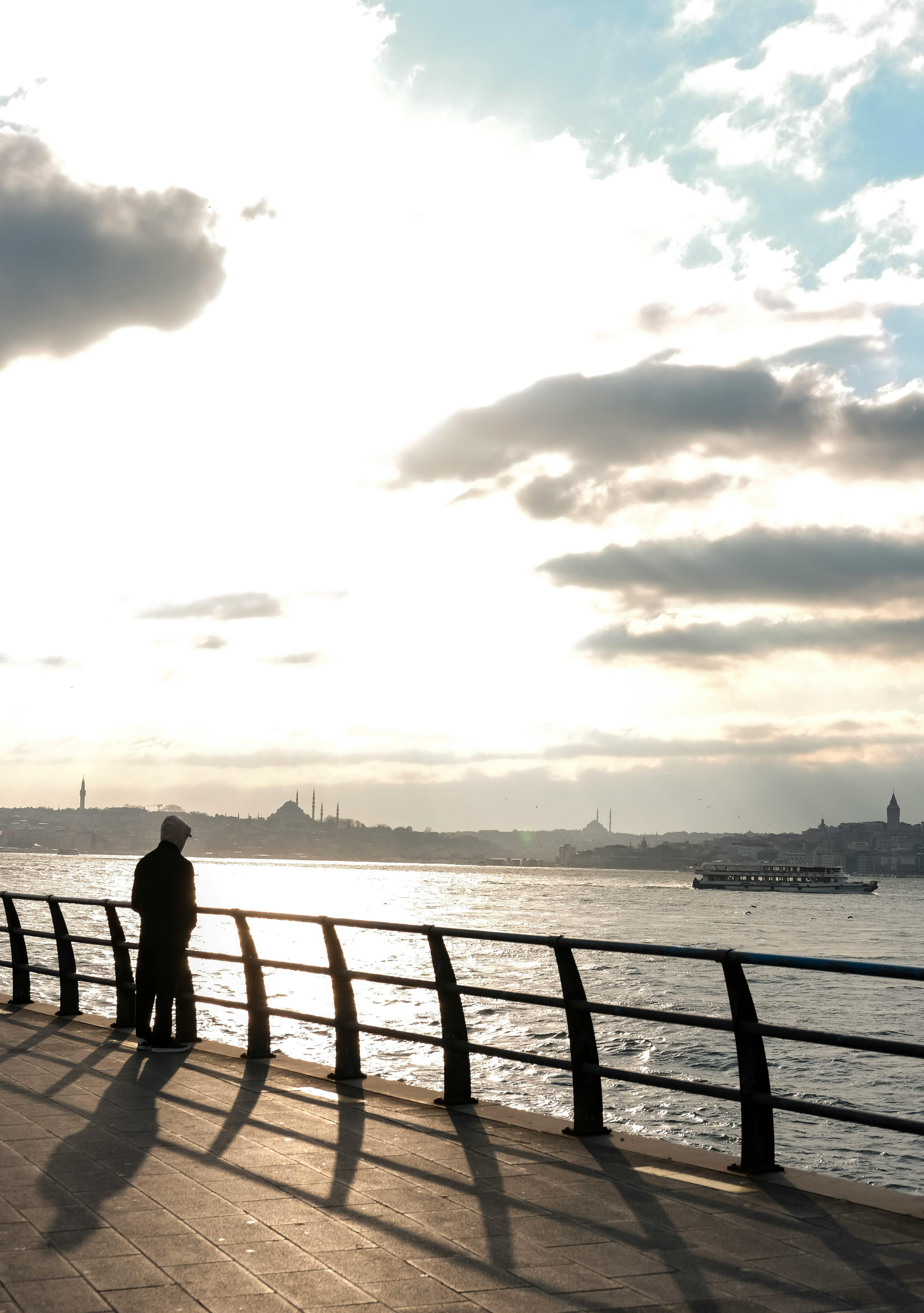 gratis Een sereen tafereel van een stel dat geniet van de zonsondergang aan de Bosporus in Istanbul, Turkije. Stockfoto