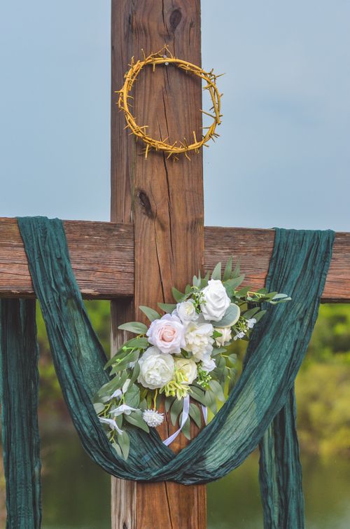 Free A wooden cross adorned with flowers and a crown of thorns, symbolizing spirituality and faith. Stock Photo