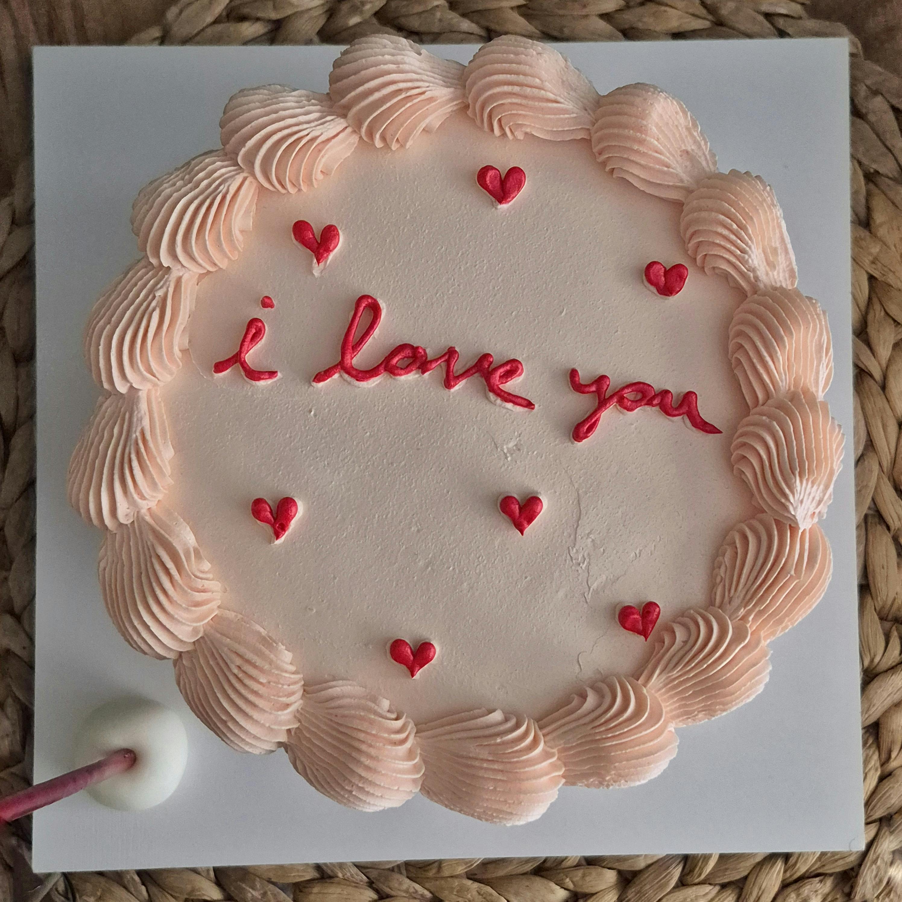 免費 一款裝飾精美的蛋糕，上面寫著「我愛你」字樣，點綴著心形圖案。非常適合浪漫場合。 圖庫相片