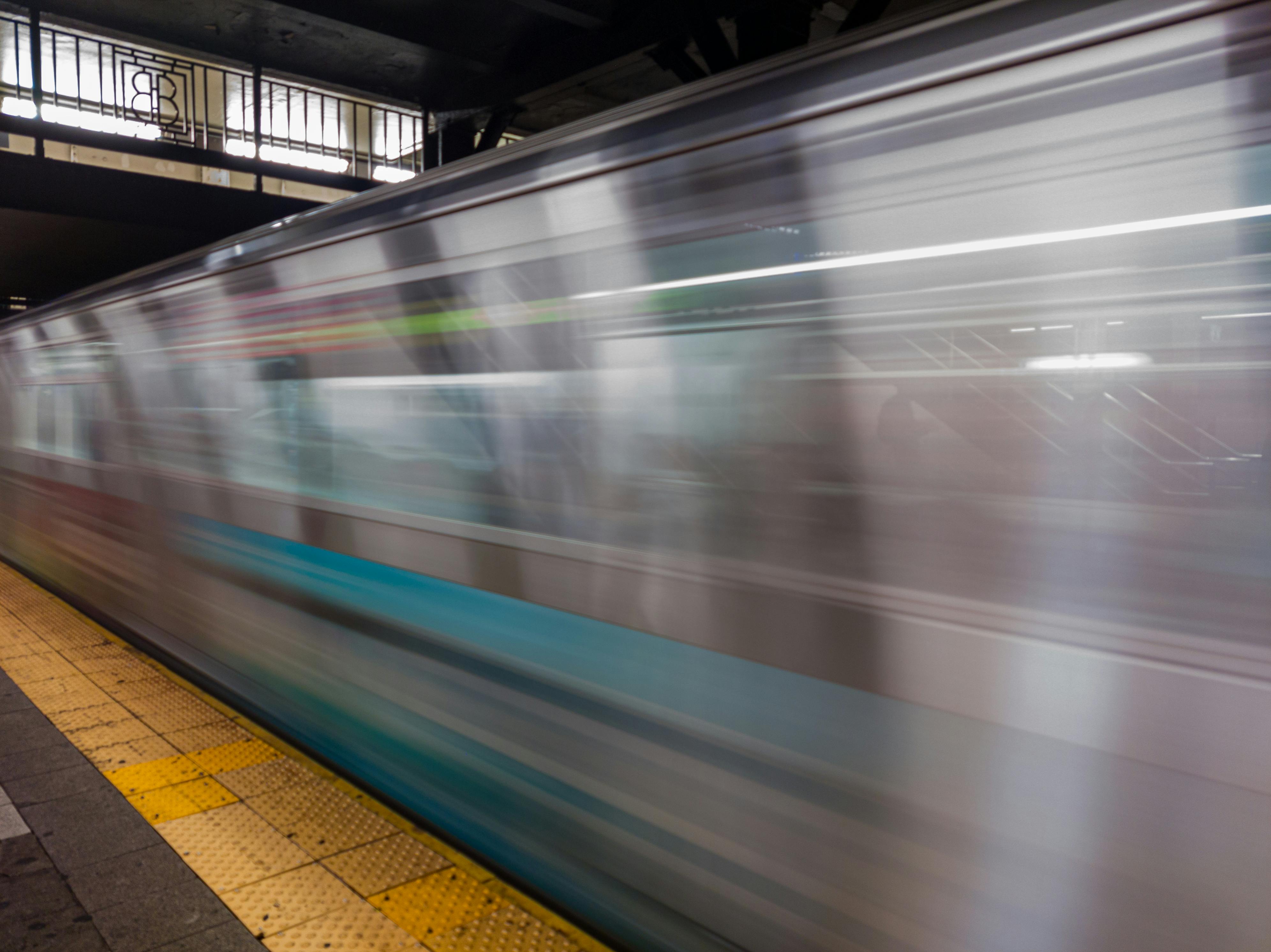 Kostenlos Dynamische Aufnahme eines schnell fahrenden U-Bahnzugs in New York City, die die Dynamik des städtischen Nahverkehrs veranschaulicht. Stock-Foto