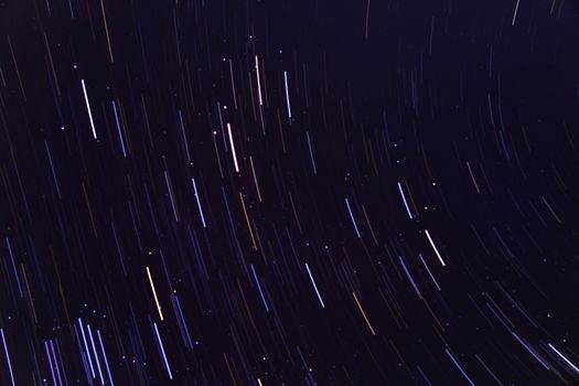 Stunning long exposure image capturing vivid star trails against a deep night sky, showcasing celestial movement.