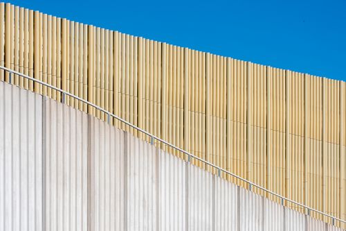 Free Minimalist architectural facade with wooden slats under a bright blue sky. Stock Photo