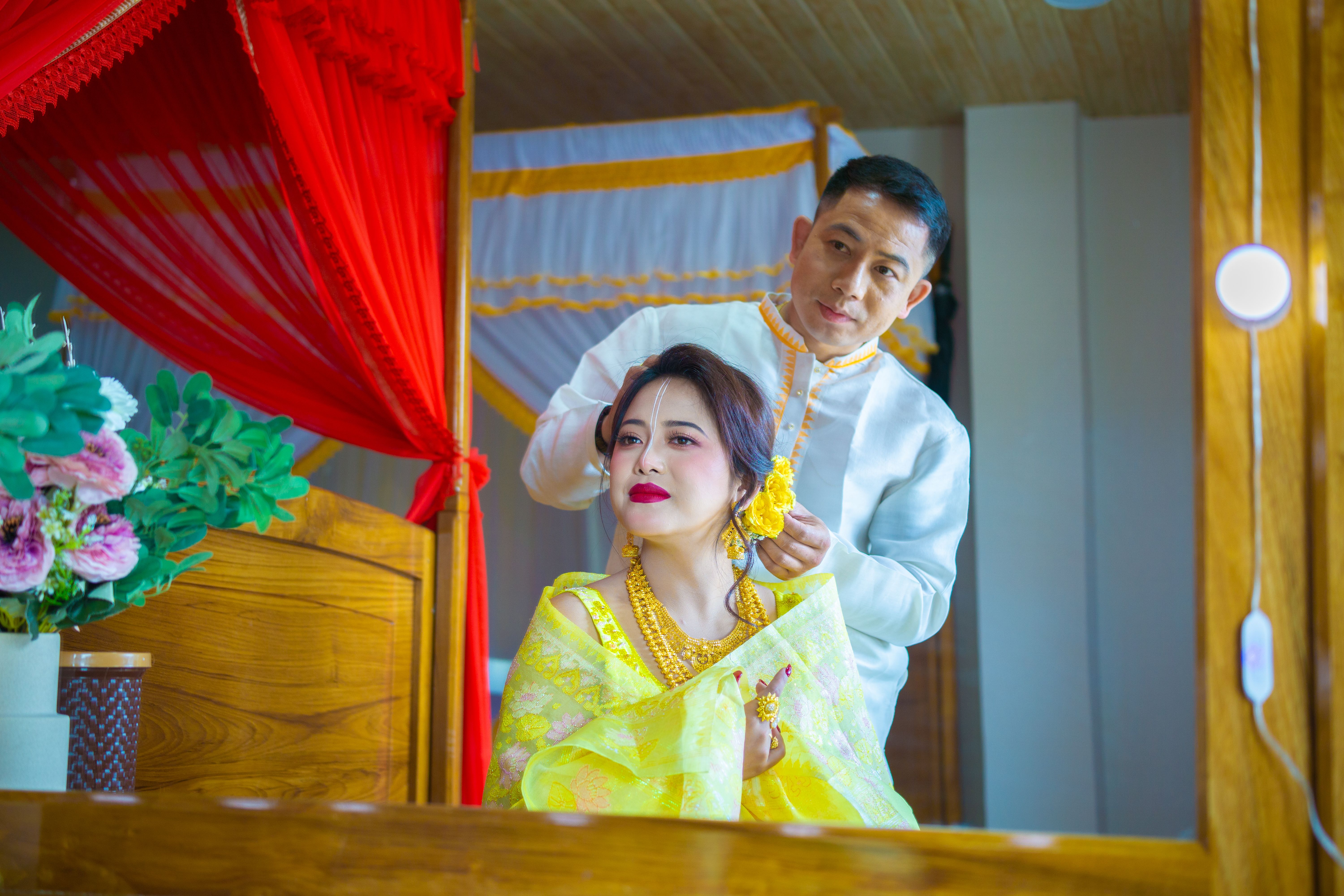 A couple dressing in vibrant traditional attire, preparing for a cultural ceremony.