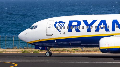 Free Side view of a commercial airplane on the runway near the ocean in Spain. Stock Photo