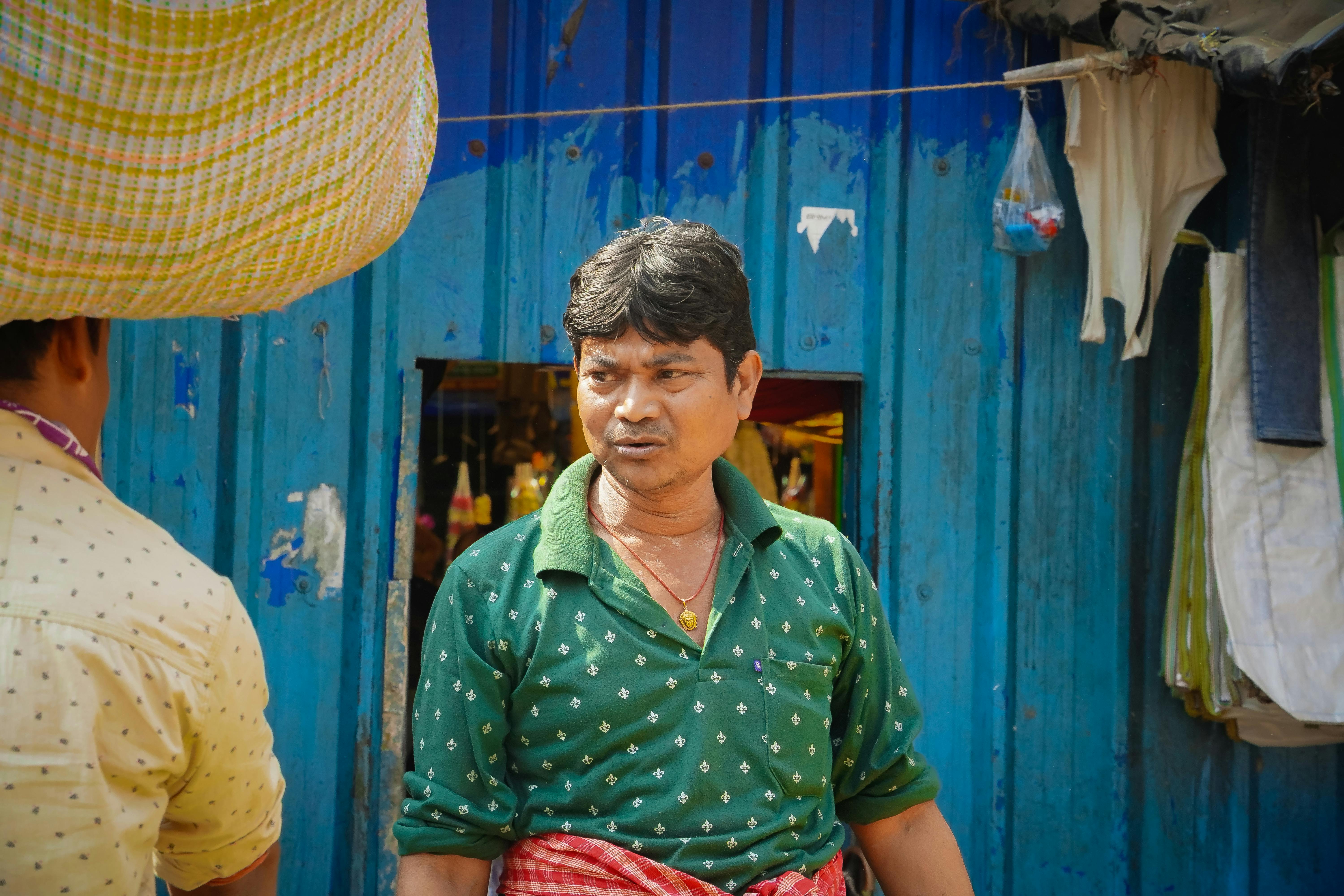 grátis Homem em trajes tradicionais em um mercado vibrante na Índia. Capturando o cotidiano. Foto profissional