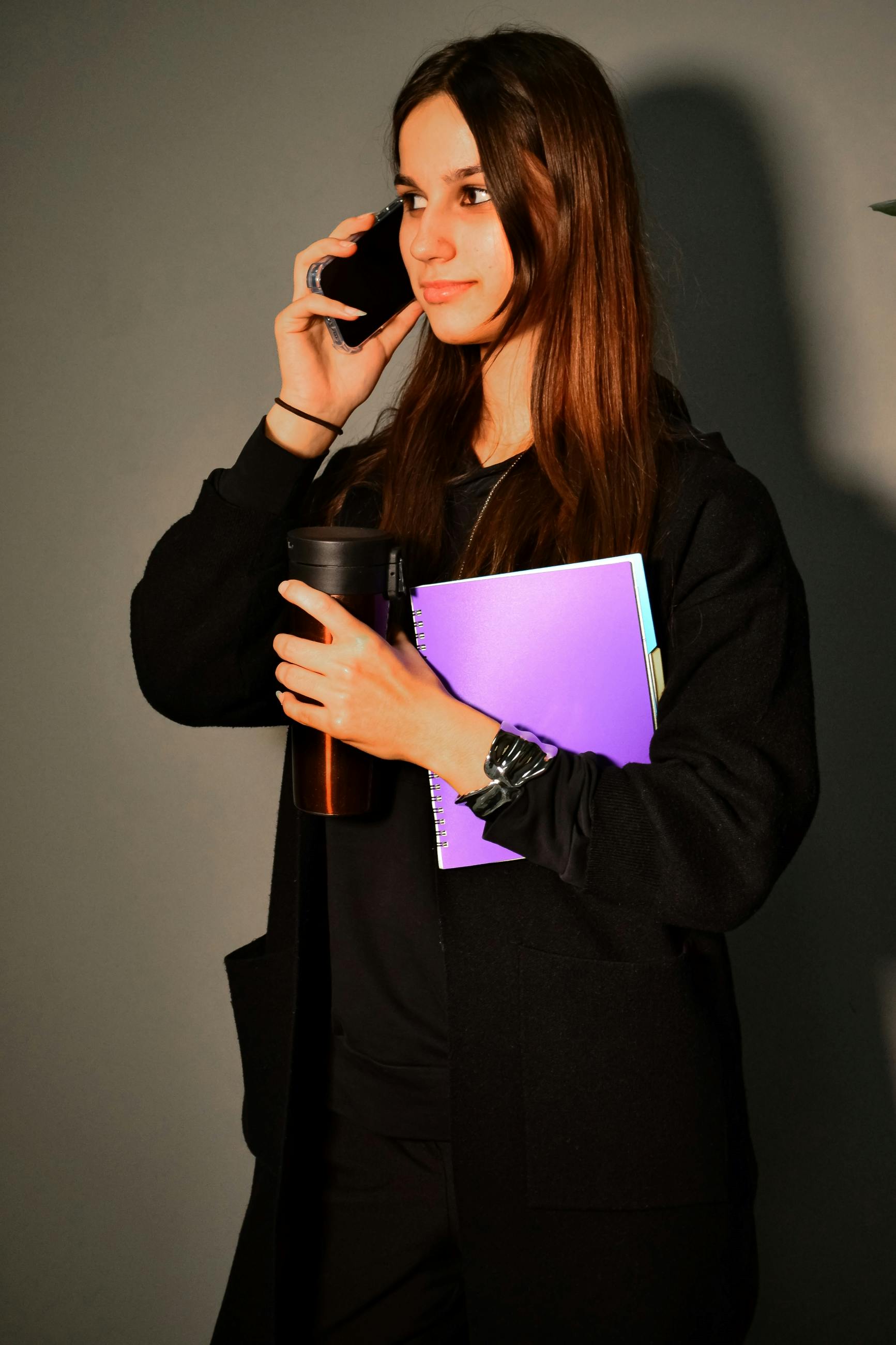 Gratis Empresaria con un cuaderno y una taza de café, hablando por teléfono, vestida de forma profesional. Foto de stock