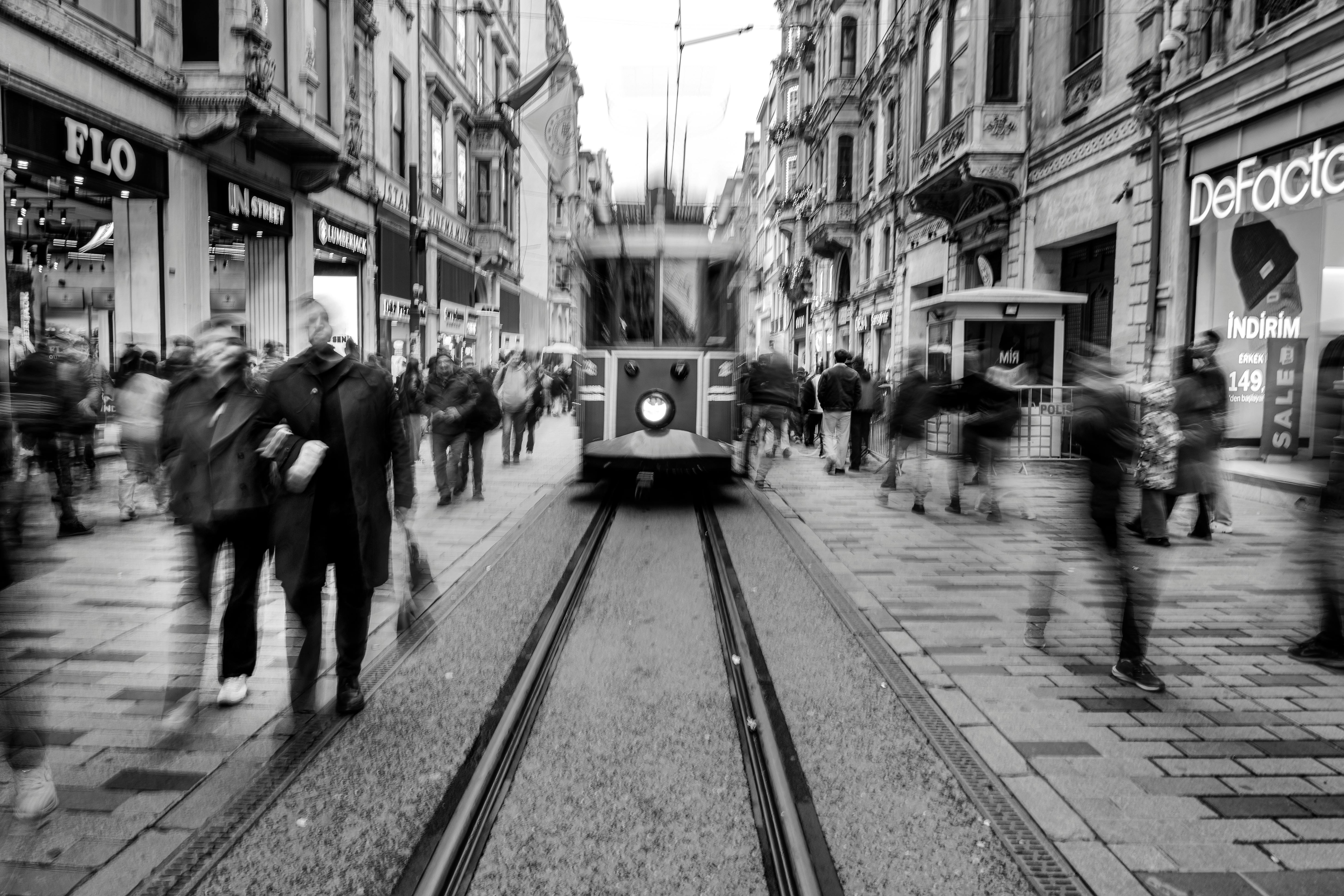 Gratuit Photo en noir et blanc d'un tramway historique dans une rue animée d'Istanbul, avec des piétons flous. Photos