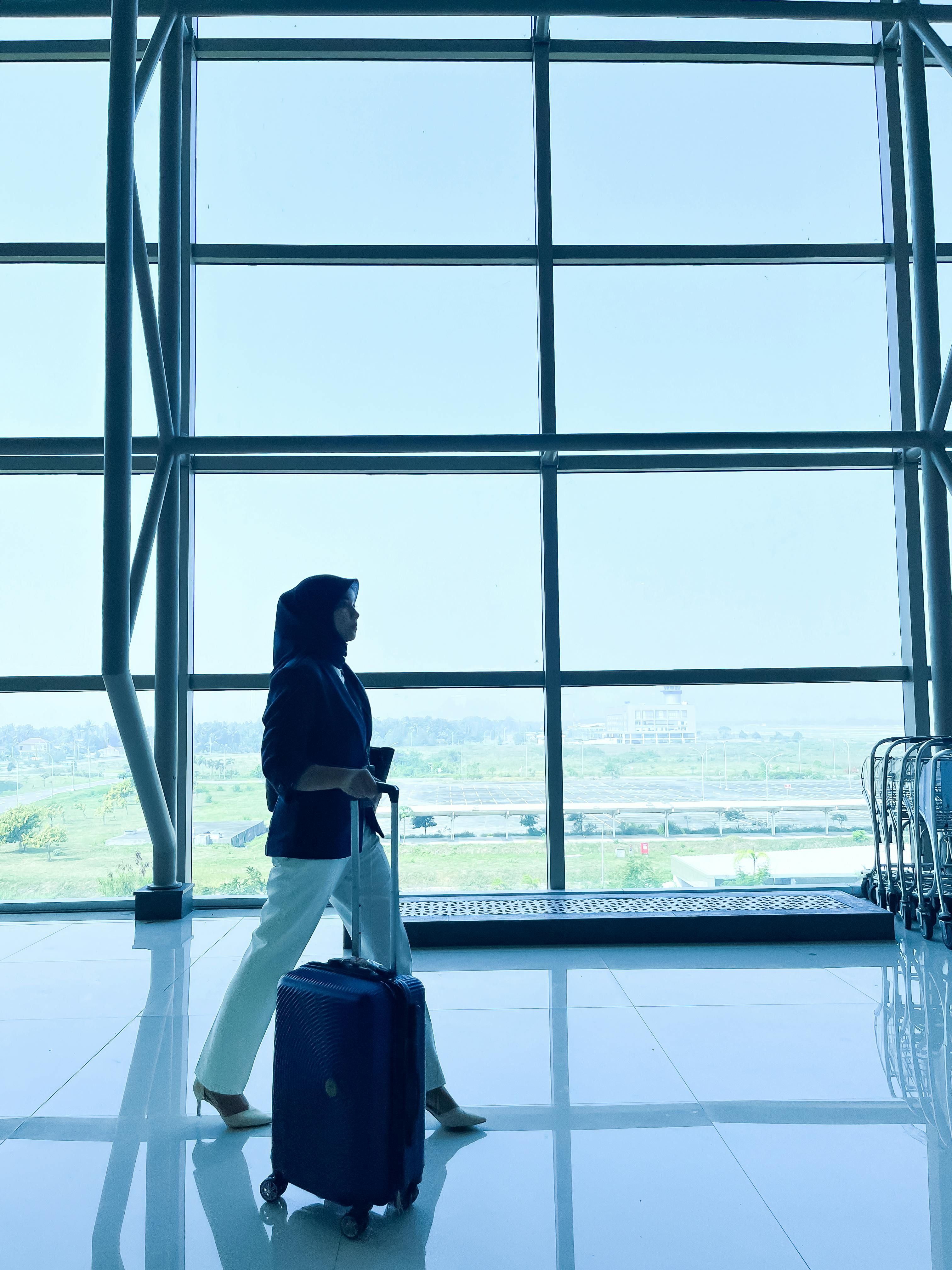 無料 インドネシアの空港を荷物を持って歩く旅行者のシルエット。 写真素材