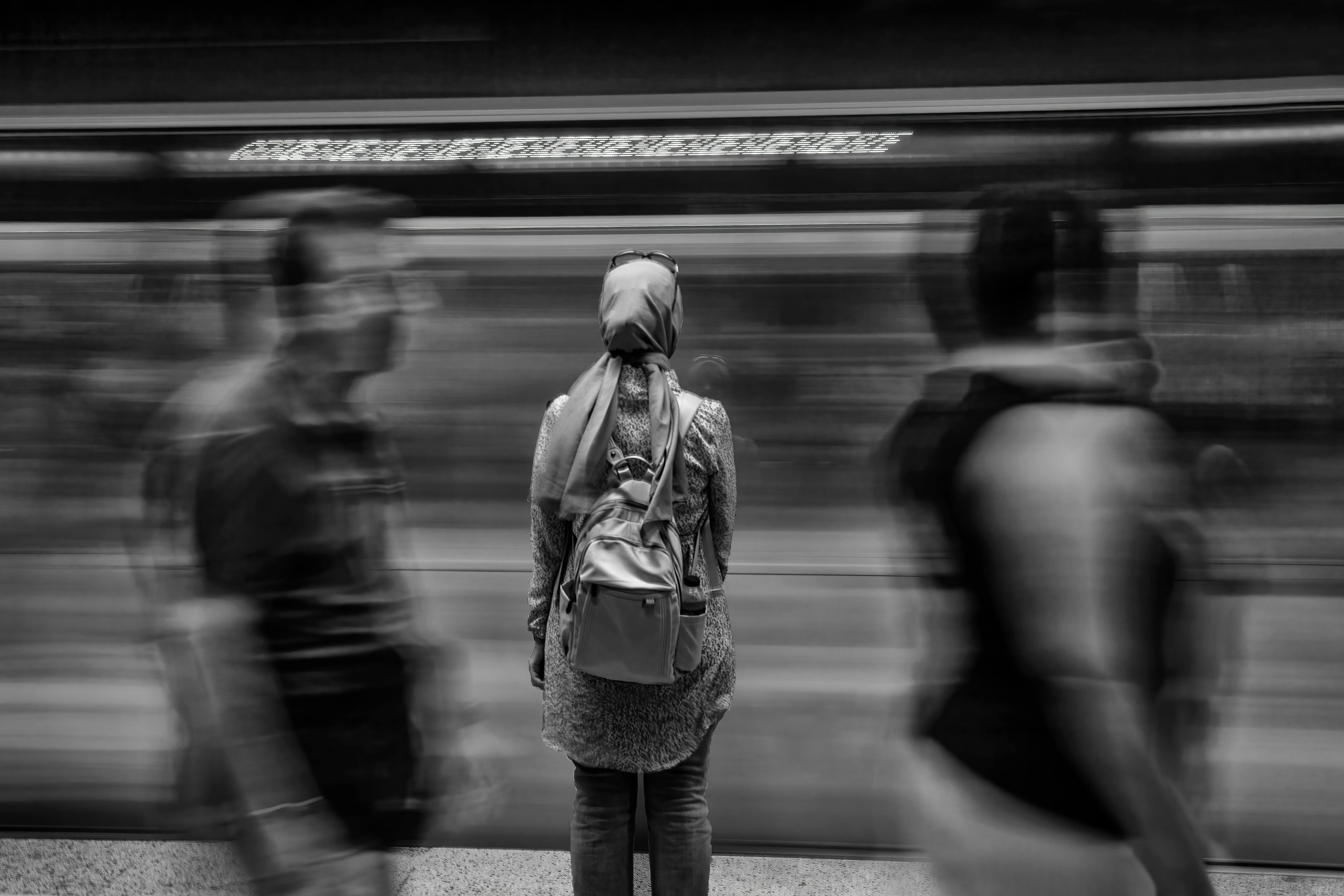Zadarmo Žena v rušnej stanici metra s rozmazaným pohybom prechádzajúceho vlaku. Fotka z fotobanky