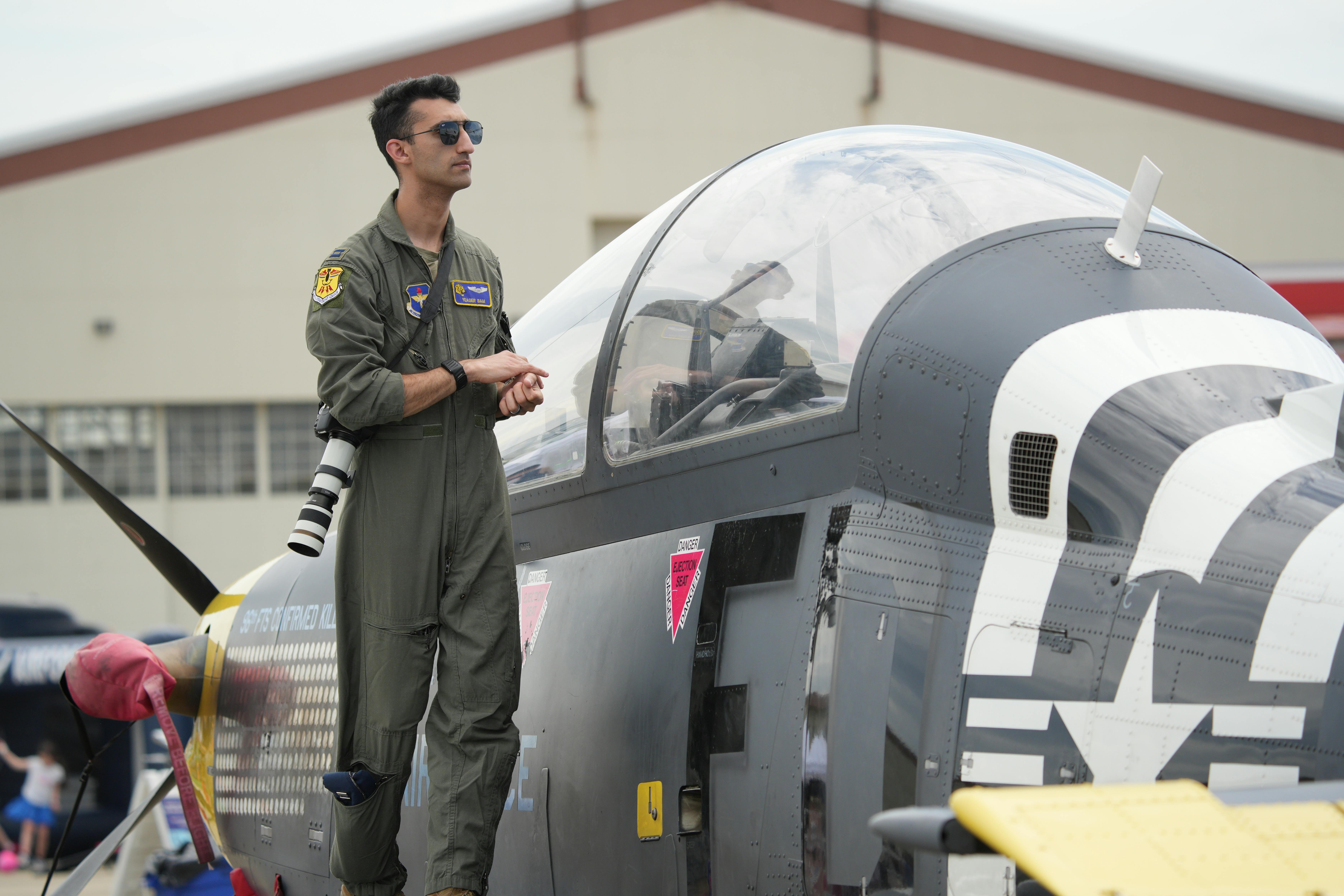 免费 在弗吉尼亚州汉普顿举行的航展上，一名军用飞行员站在一架战斗机上。 素材图片