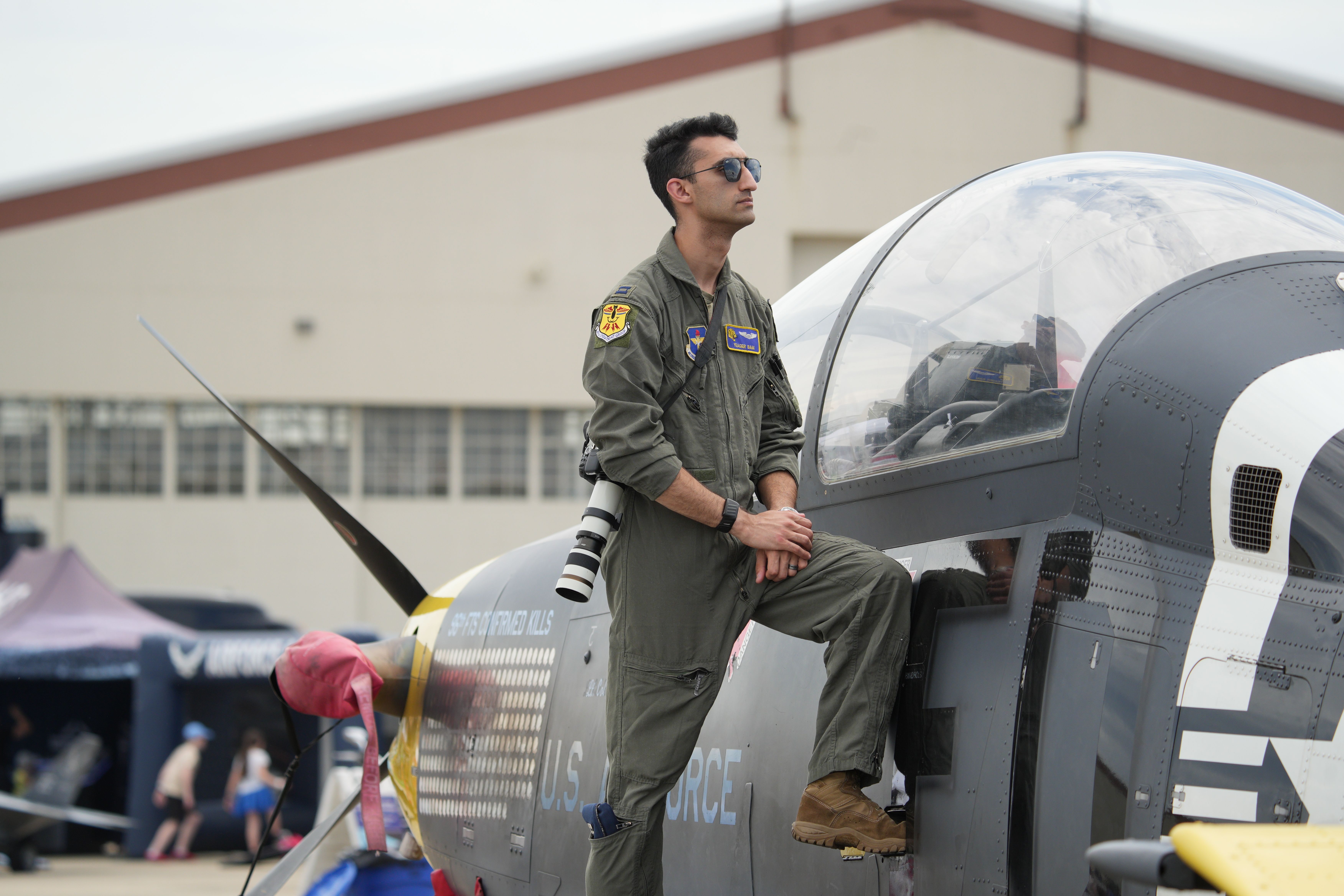 US Air Force pilot in uniform stands by fighter jet at airshow in Hampton, Virginia.