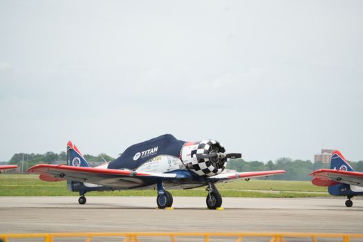 A classic fighter jet with vibrant red and blue accents parked at a Hampton airfield.