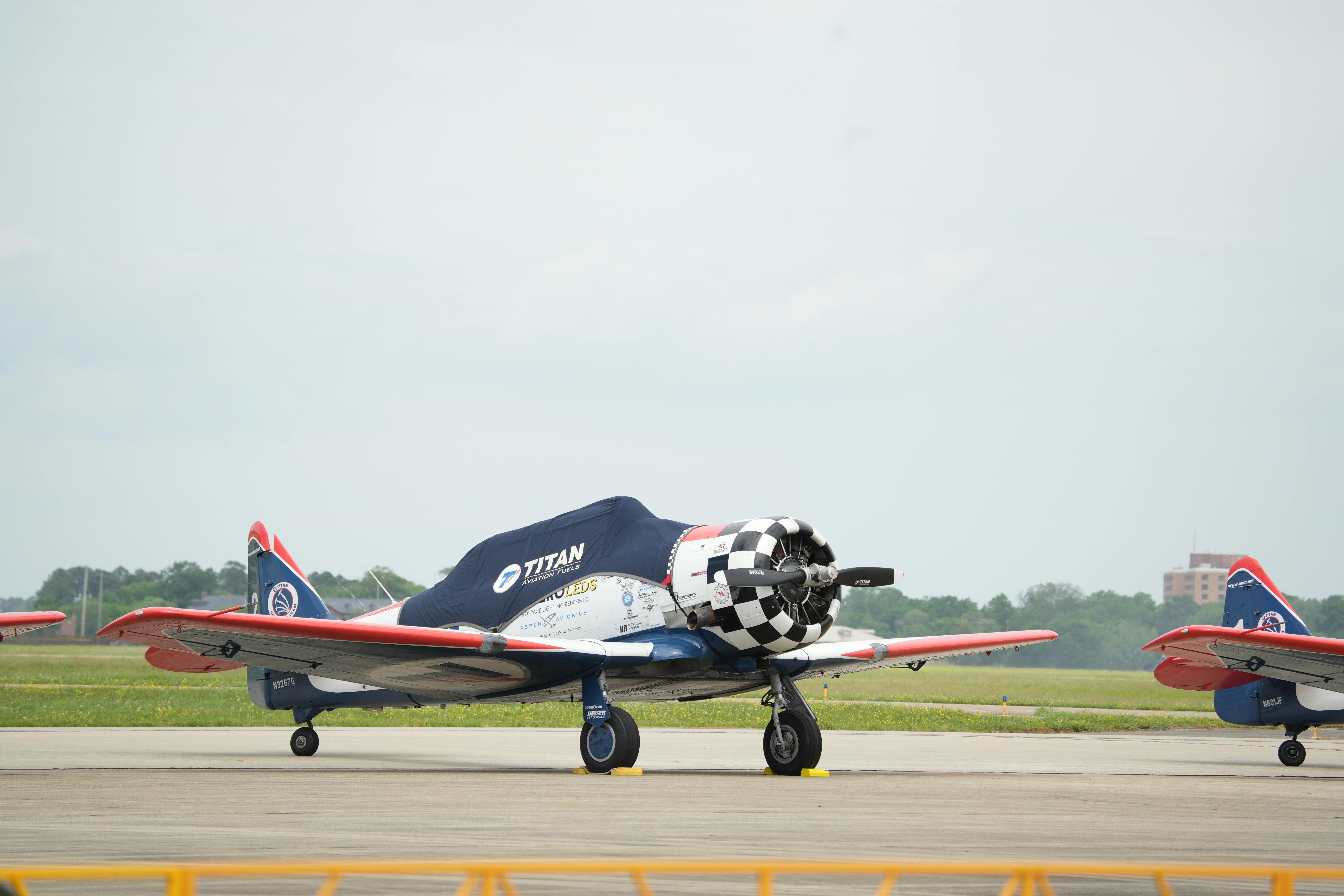 Gratuit Un avion de chasse classique aux couleurs rouge et bleu éclatantes, stationné sur un aérodrome de Hampton. Photos