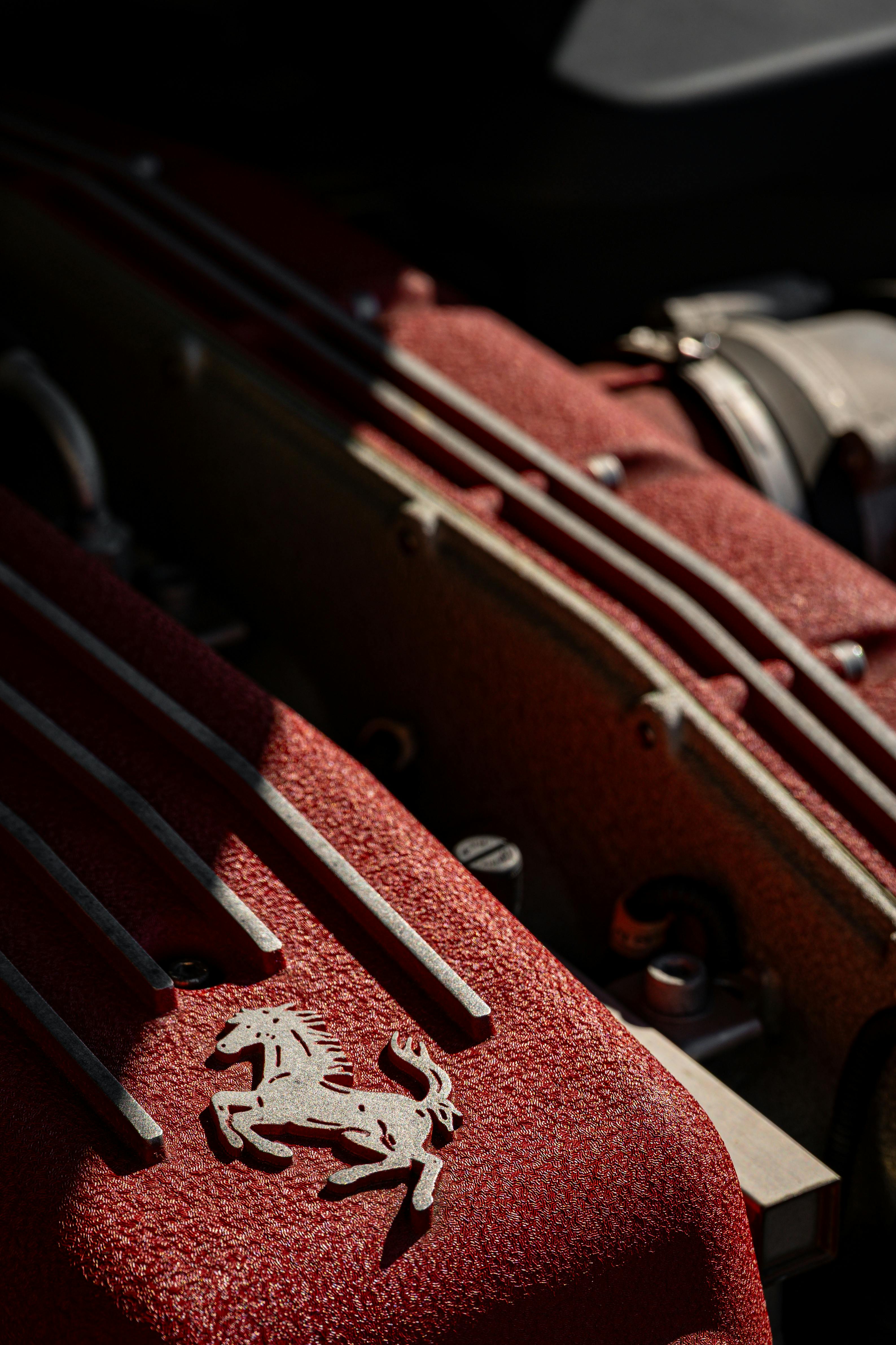 ingyenes Részletes nézet texturált piros motorburkolatokról, amelyeken egy ló emblémája látható Lengyelországban. Stockfotó