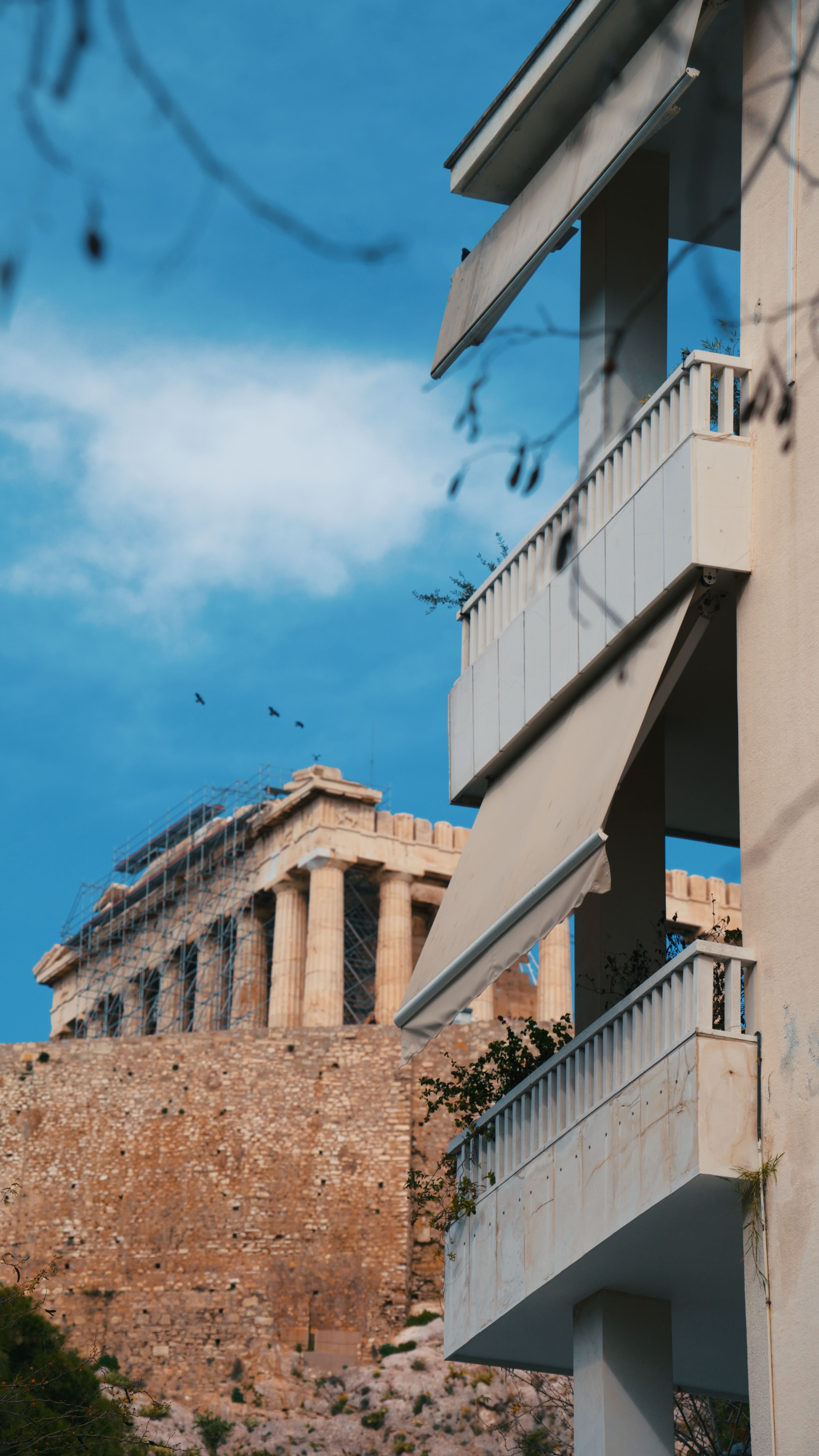 Contrasting view of the ancient Parthenon and modern architecture in Athens, Greece.