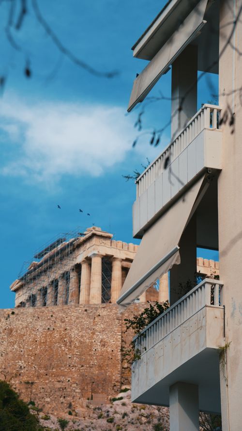 Free Contrasting view of the ancient Parthenon and modern architecture in Athens, Greece. Stock Photo