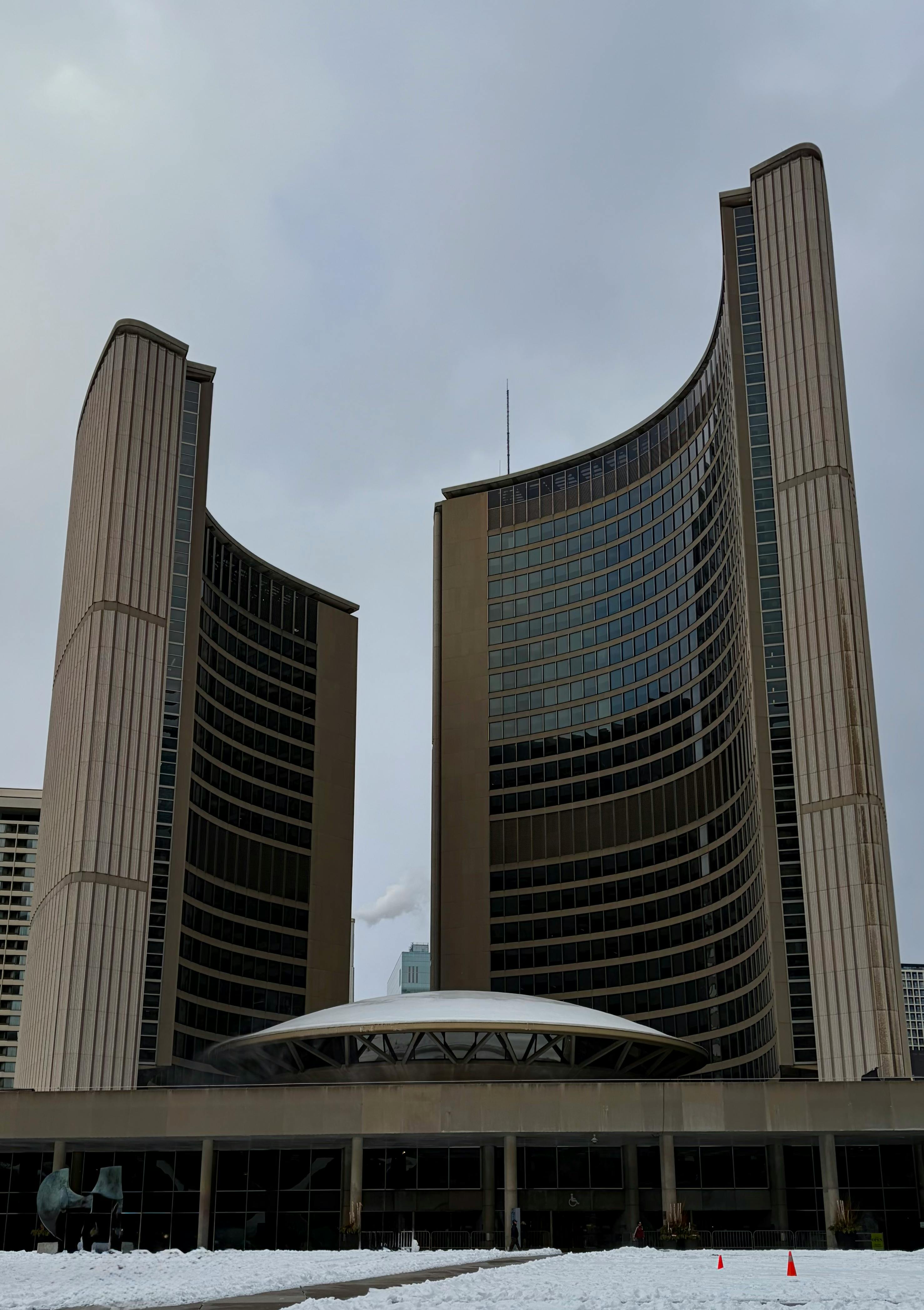 Gratis Snedækket Toronto Rådhus under en overskyet himmel, der fremviser moderne arkitektonisk design. Lagerfoto