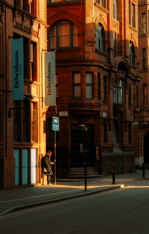 Free Warm sunset light on a classic Manchester street with Debenhams signs. Stock Photo