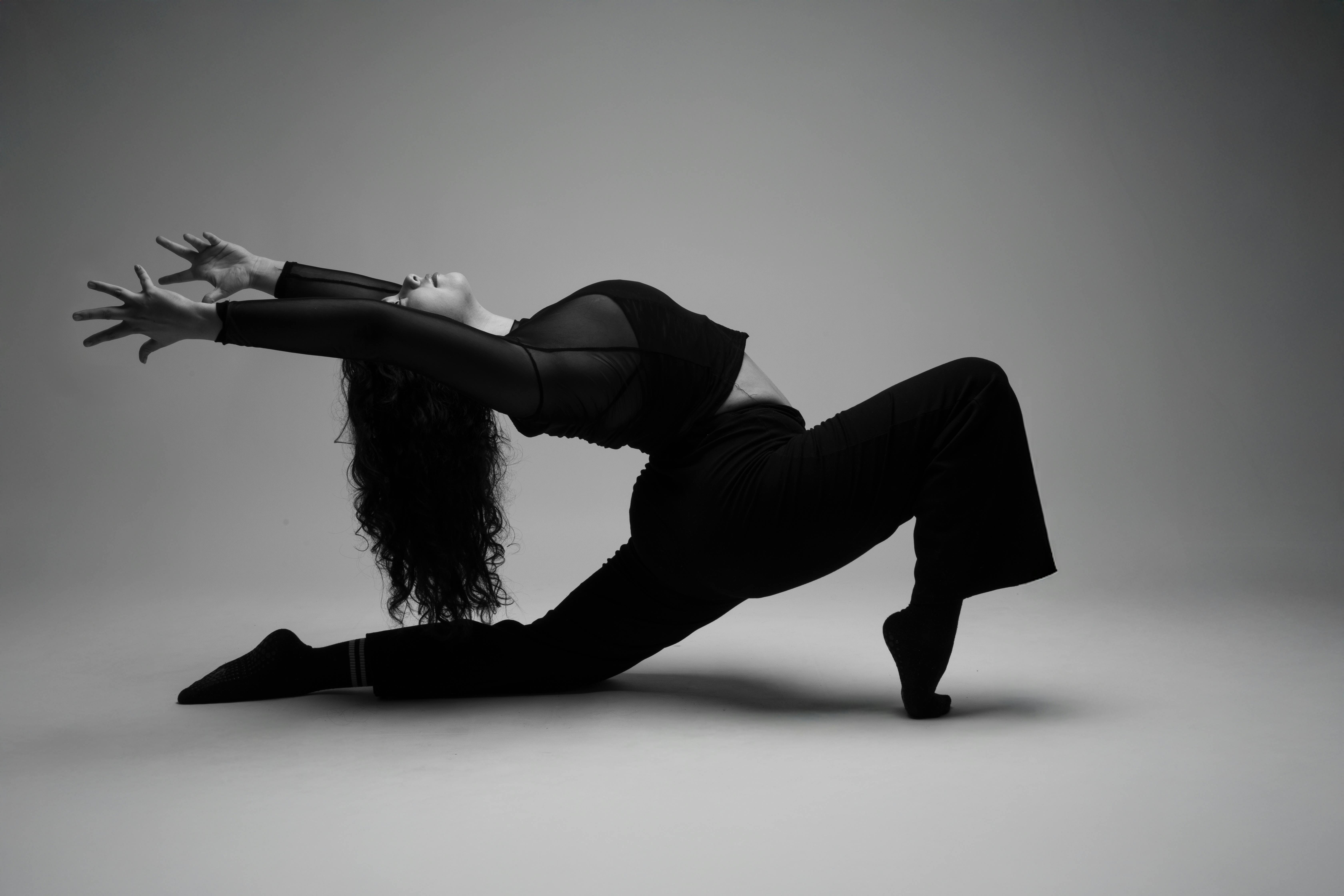 De franc Fotografia en blanc i negre d'una ballarina posant amb gràcia en un estirament dramàtic. Foto d'estoc