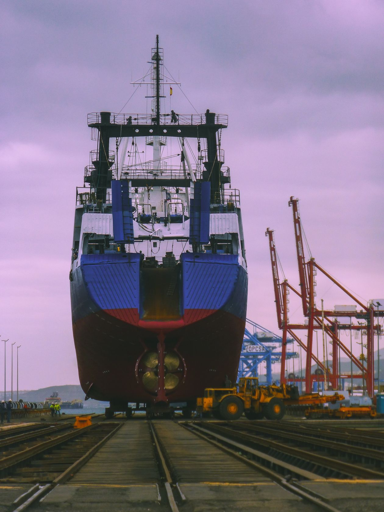 Navio de carga em estaleiro industrial ao amanhecer, simbolizando grandes investimentos e risco financeiro