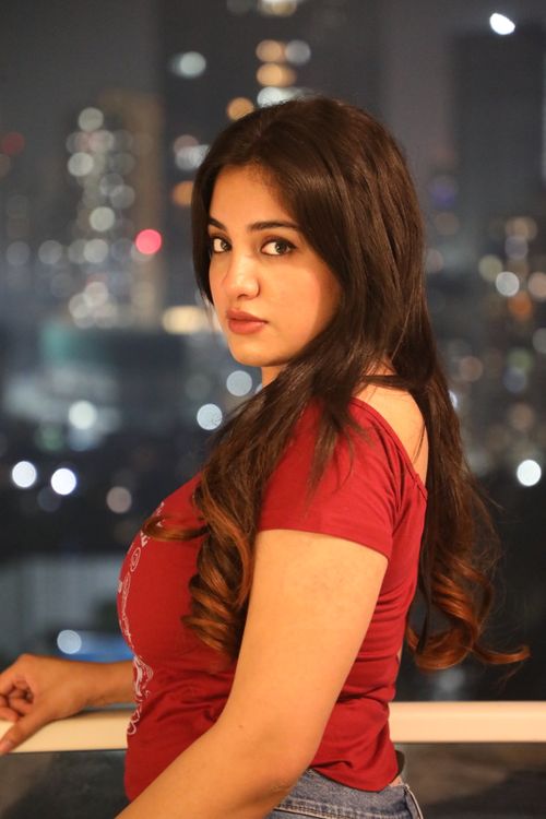 Free Captivating portrait of a woman against a sparkling urban night skyline. Stock Photo