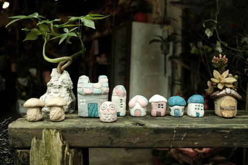 Free Artistic display of small clay houses and succulents on a rustic wooden bench indoors. Stock Photo