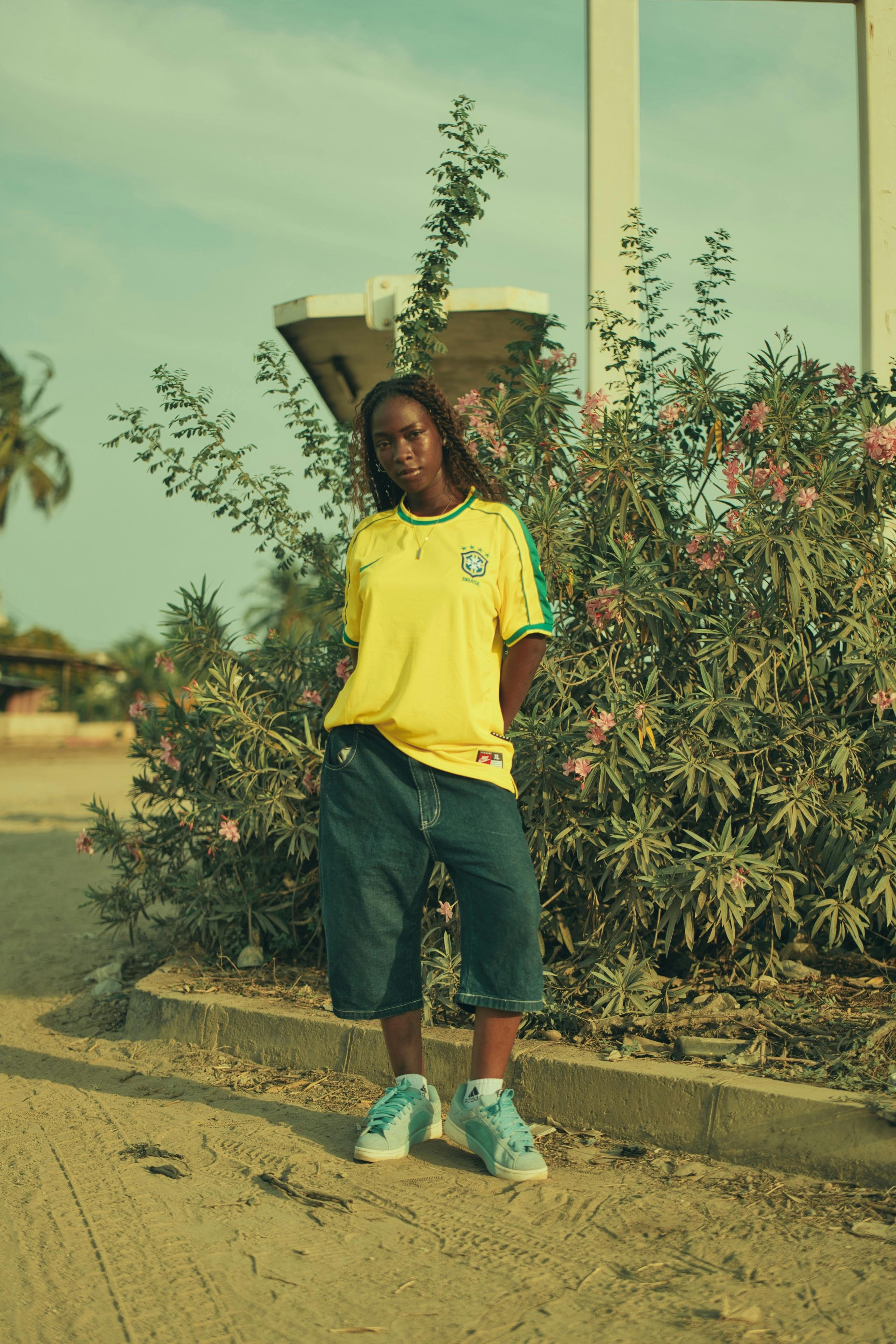 gratis Een jonge vrouw staat in casual sportkleding te midden van het gebladerte in de buitenlucht. Stockfoto