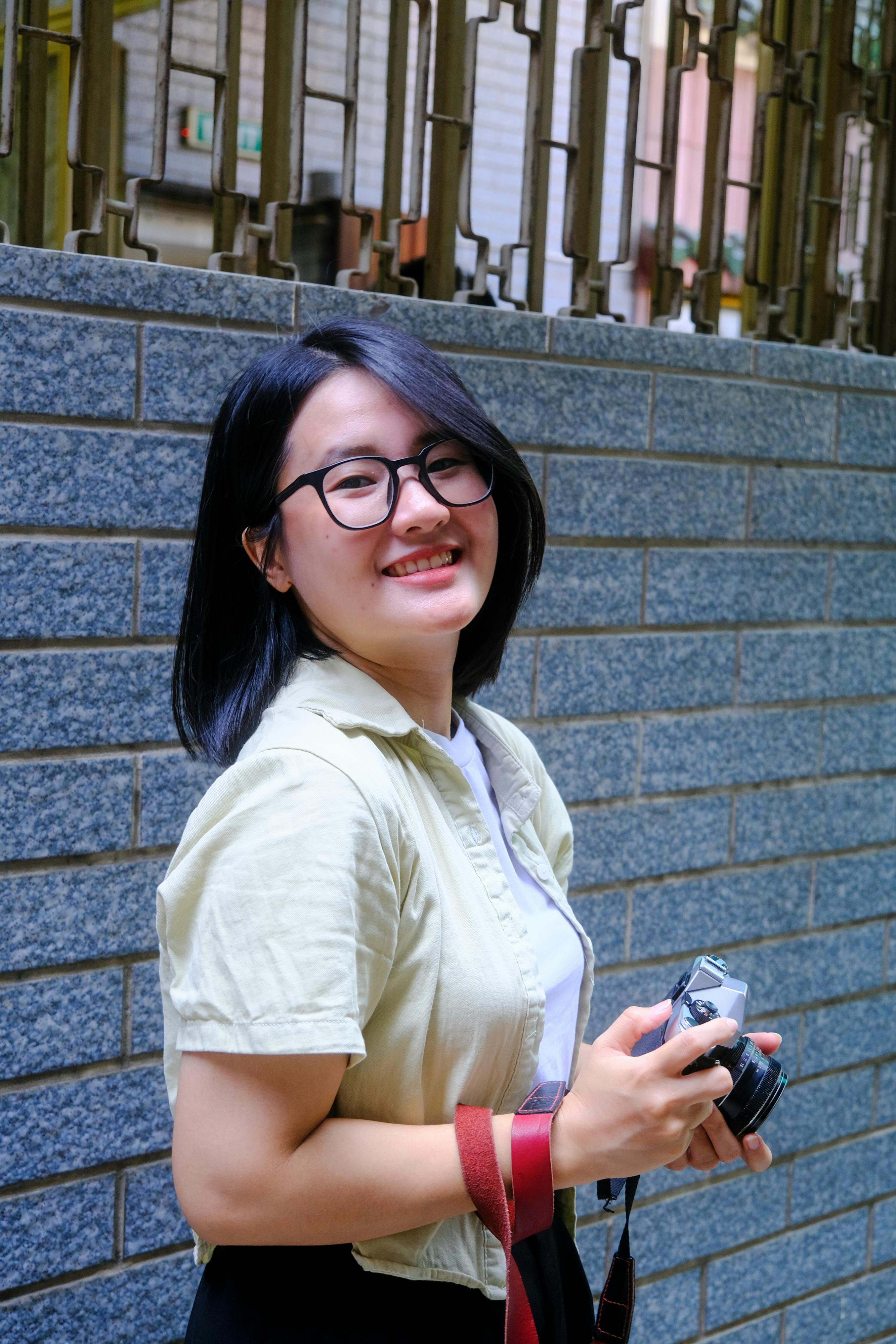 ฟรี หญิงสาวถือกล้องถ่ายภาพเพลิดเพลินกับช่วงเวลาหนึ่งในเมืองเว้ ประเทศเวียดนาม ภาพถ่ายกลางแจ้งในวันที่อากาศสดใส คลังภาพถ่าย