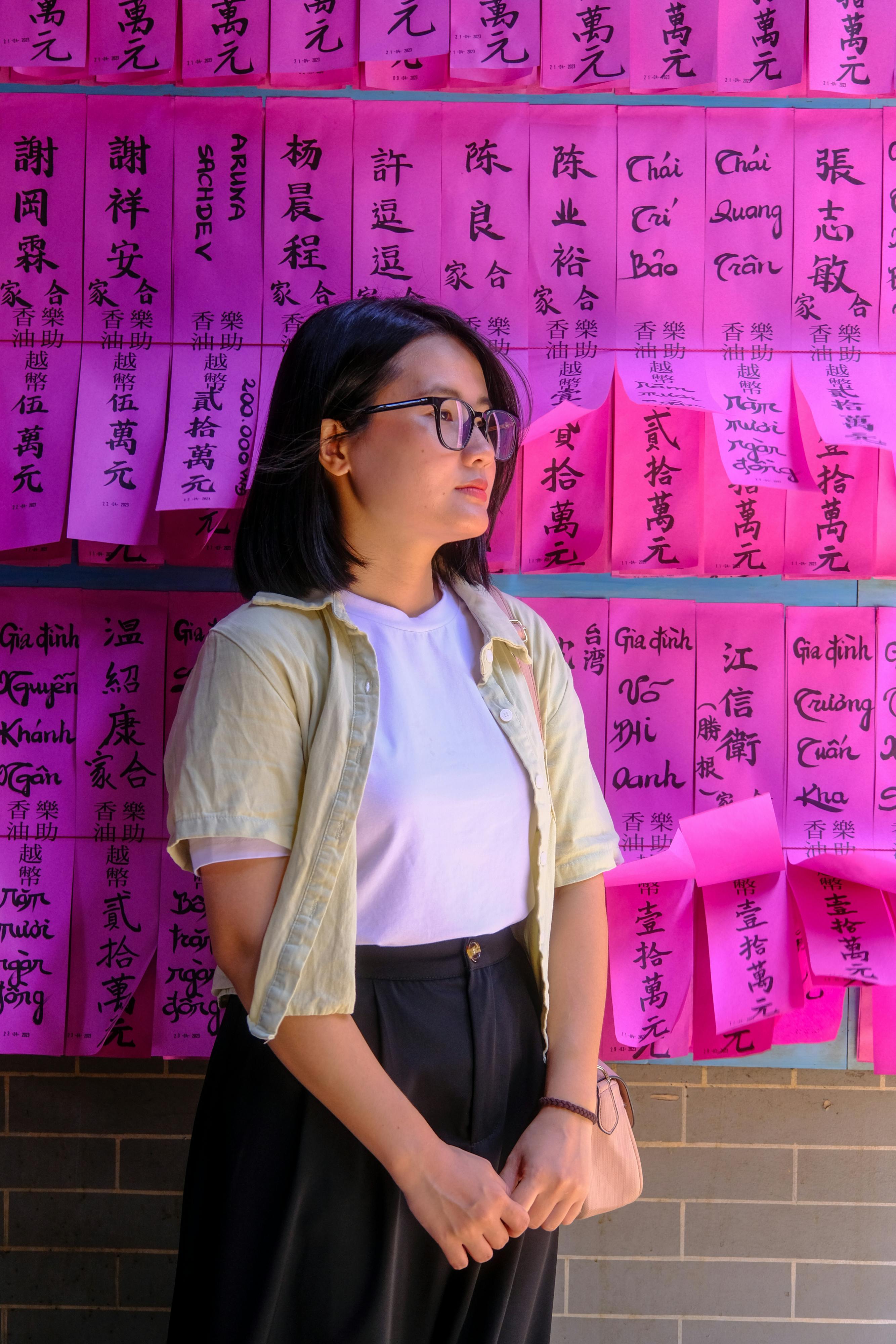 무료 베트남 후에의 전통적인 기도벽 앞에서 사려 깊게 서 있는 여인의 초상. 스톡 사진