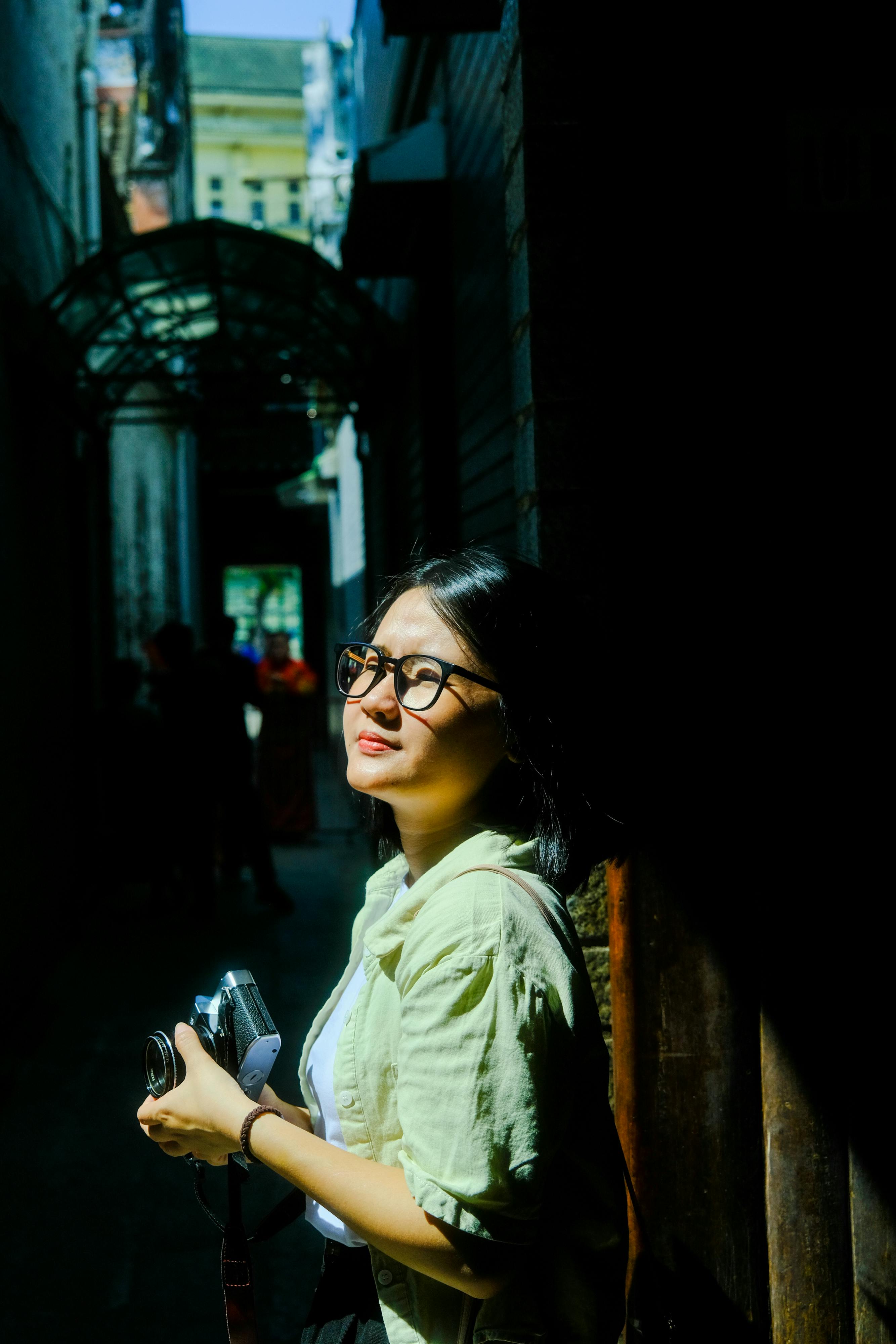 Zadarmo Mladá žena v meste Hue vo Vietname zachytená fotoaparátom v slnečnej uličke. Fotka z fotobanky