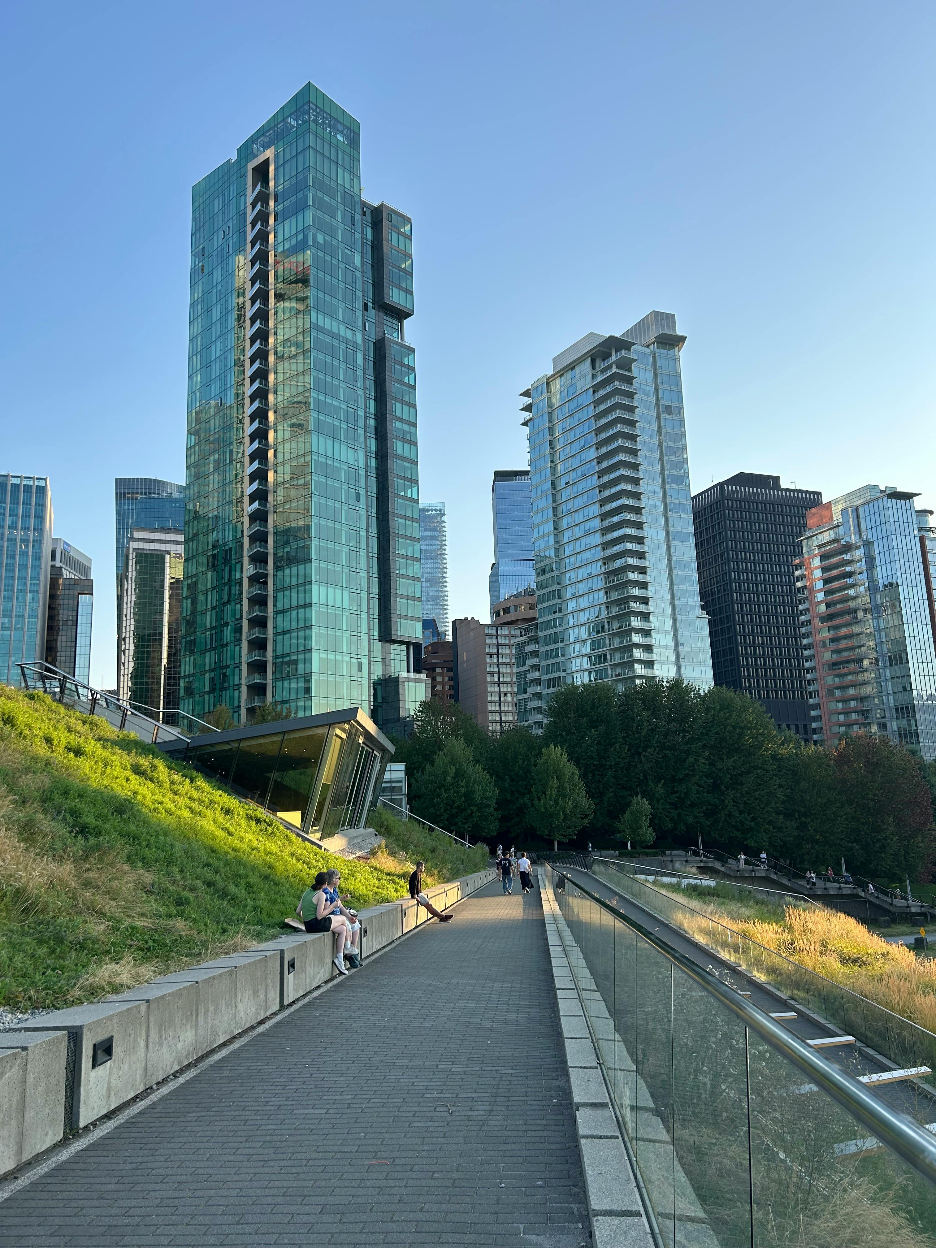 無料 バンクーバーの近代的な高層ビル群が、澄み切った青空の下、穏やかな雰囲気の中で都市建築の美しさを際立たせている。 写真素材