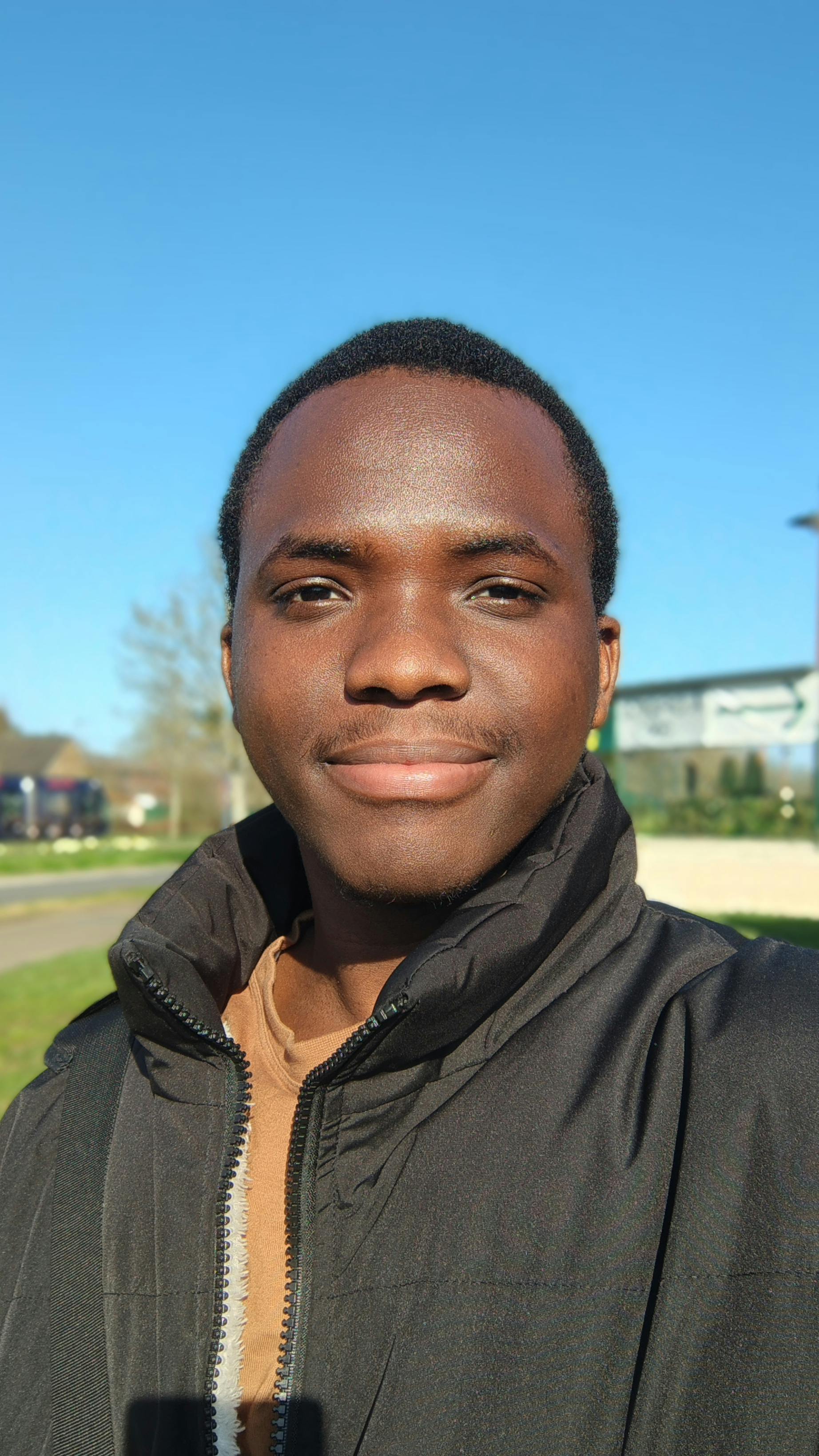 Безкоштовне Крупний план усміхненого чоловіка на вулиці з чистим блакитним небом. стокове фото