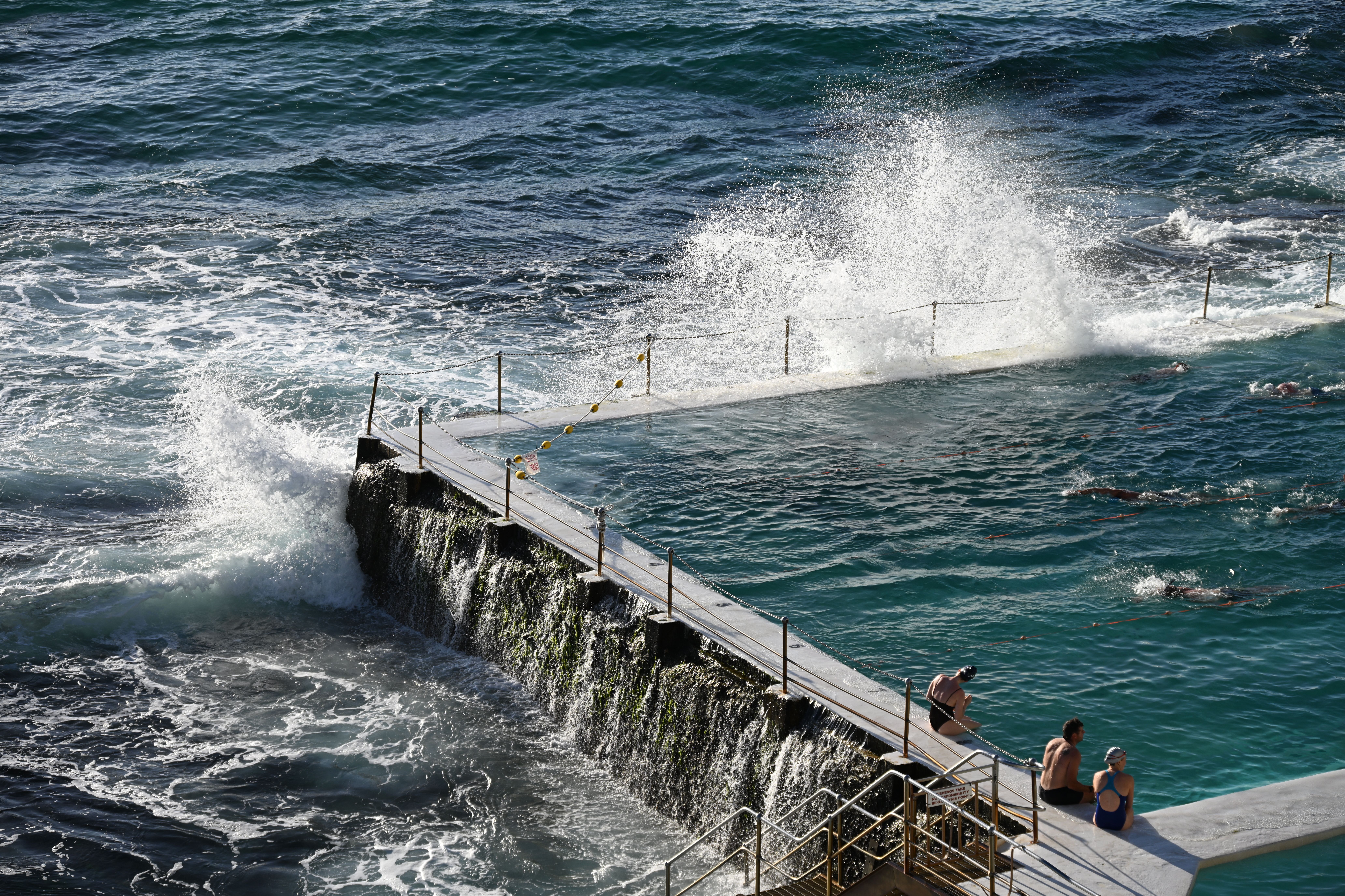 Ocean waves crashing over coastal pool · Free Stock Photo