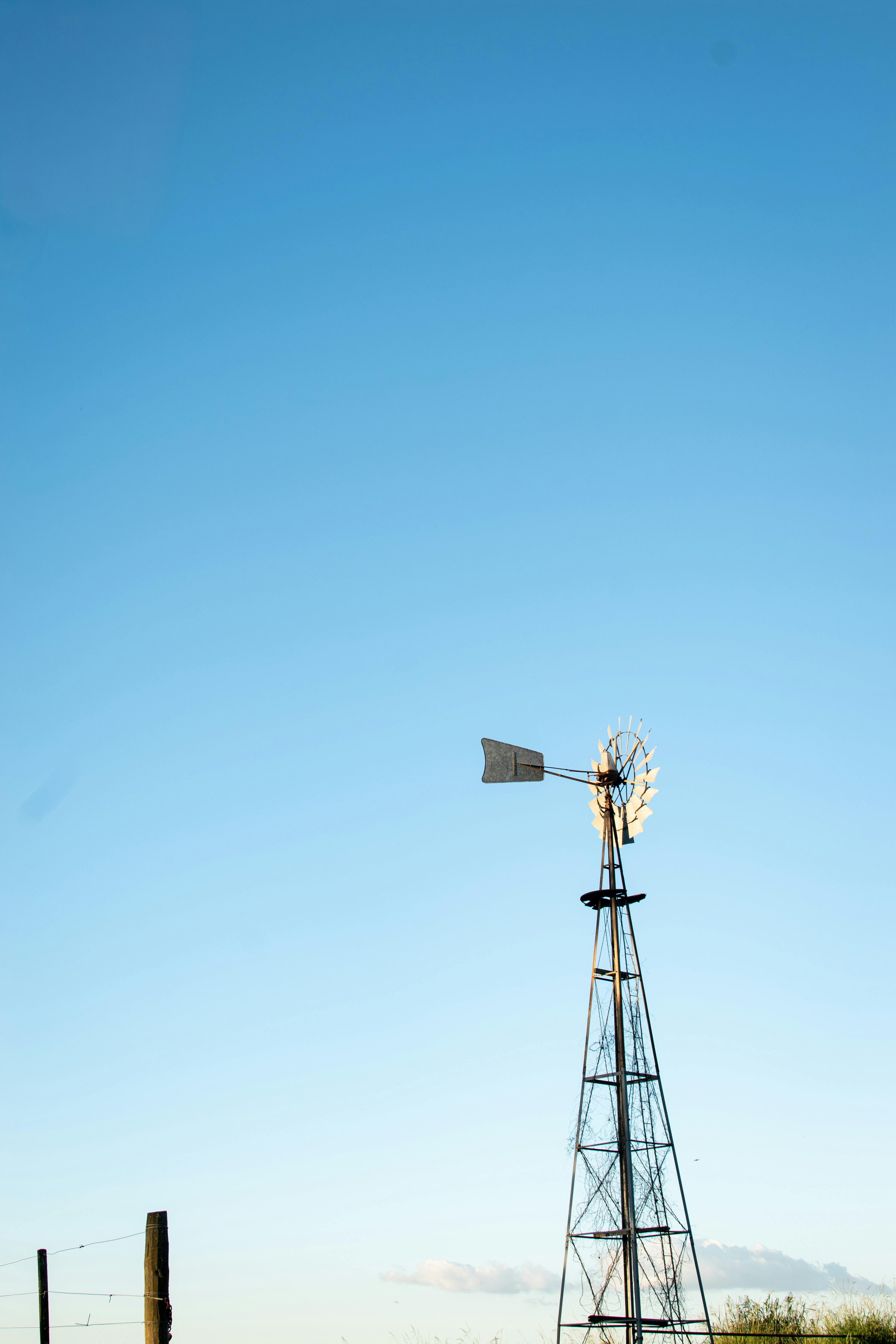 Безкоштовне Самотній вітряк стоїть на тлі чистого блакитного неба, символізуючи сільську простоту. стокове фото
