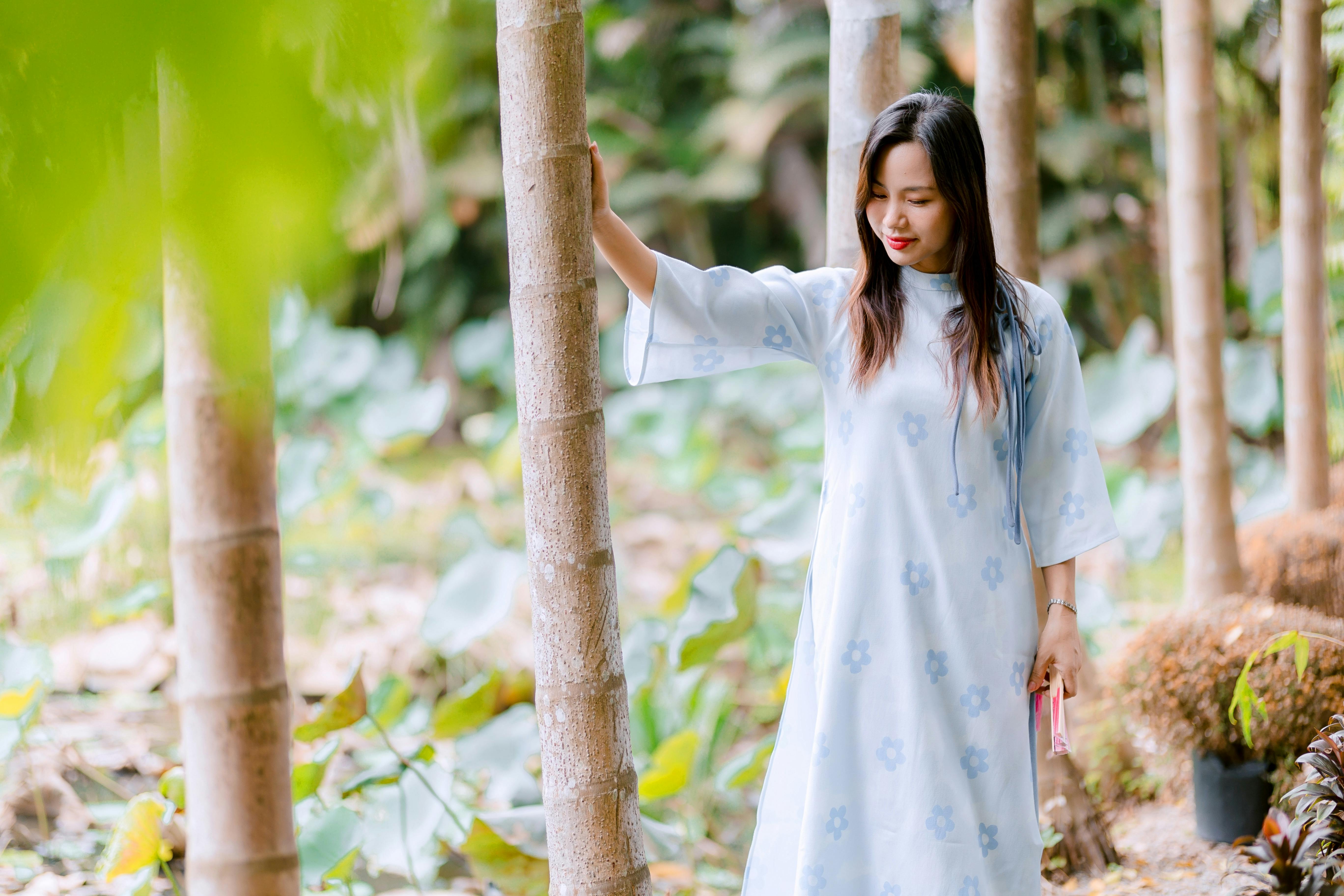 Gratis Ung kvinne i en fredelig bambuslund iført en blomsterkjole, som nyter naturen. Arkivbilde