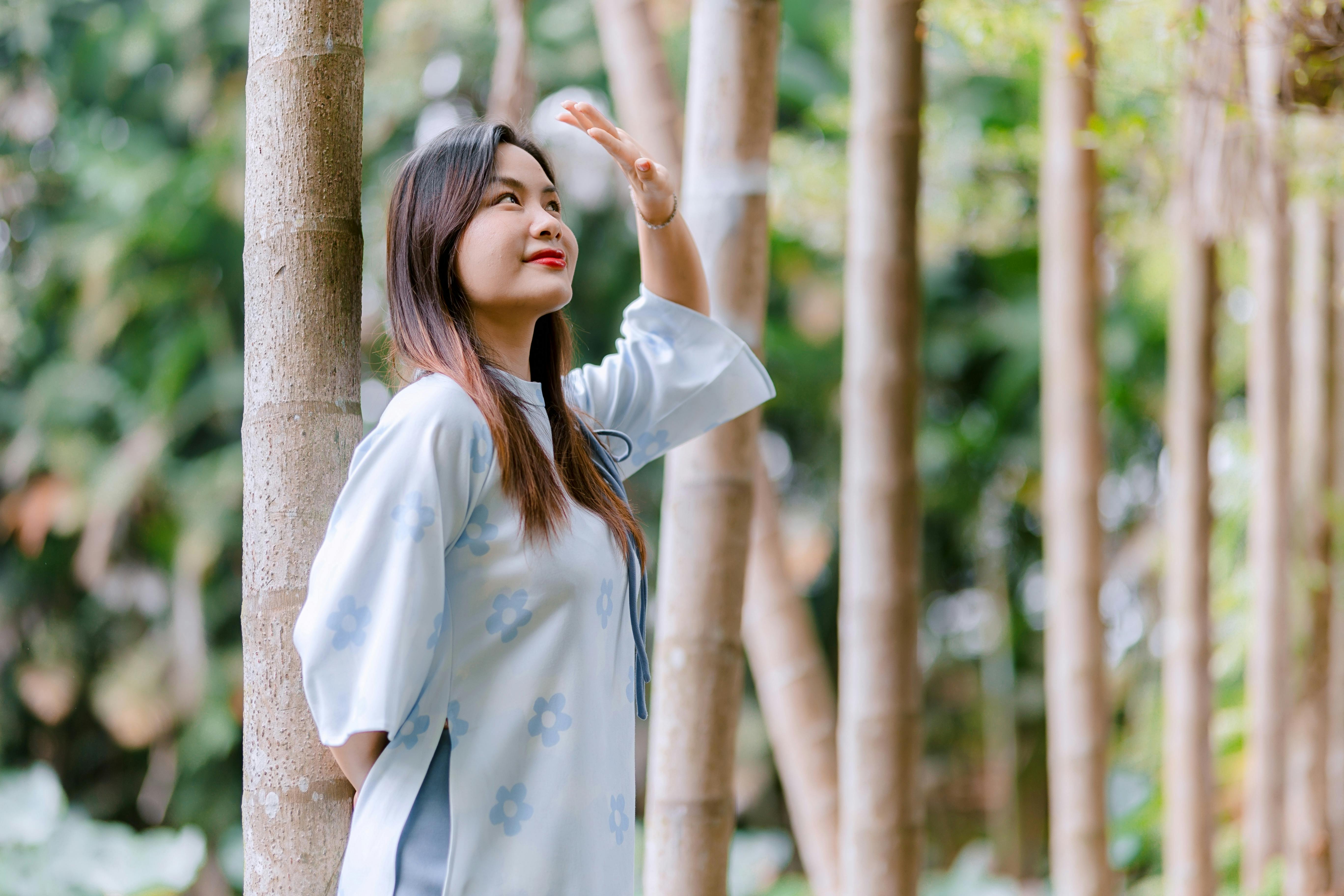 Gratis Mujer joven con un vestido azul estampado de flores en un entorno forestal sereno. Foto de stock